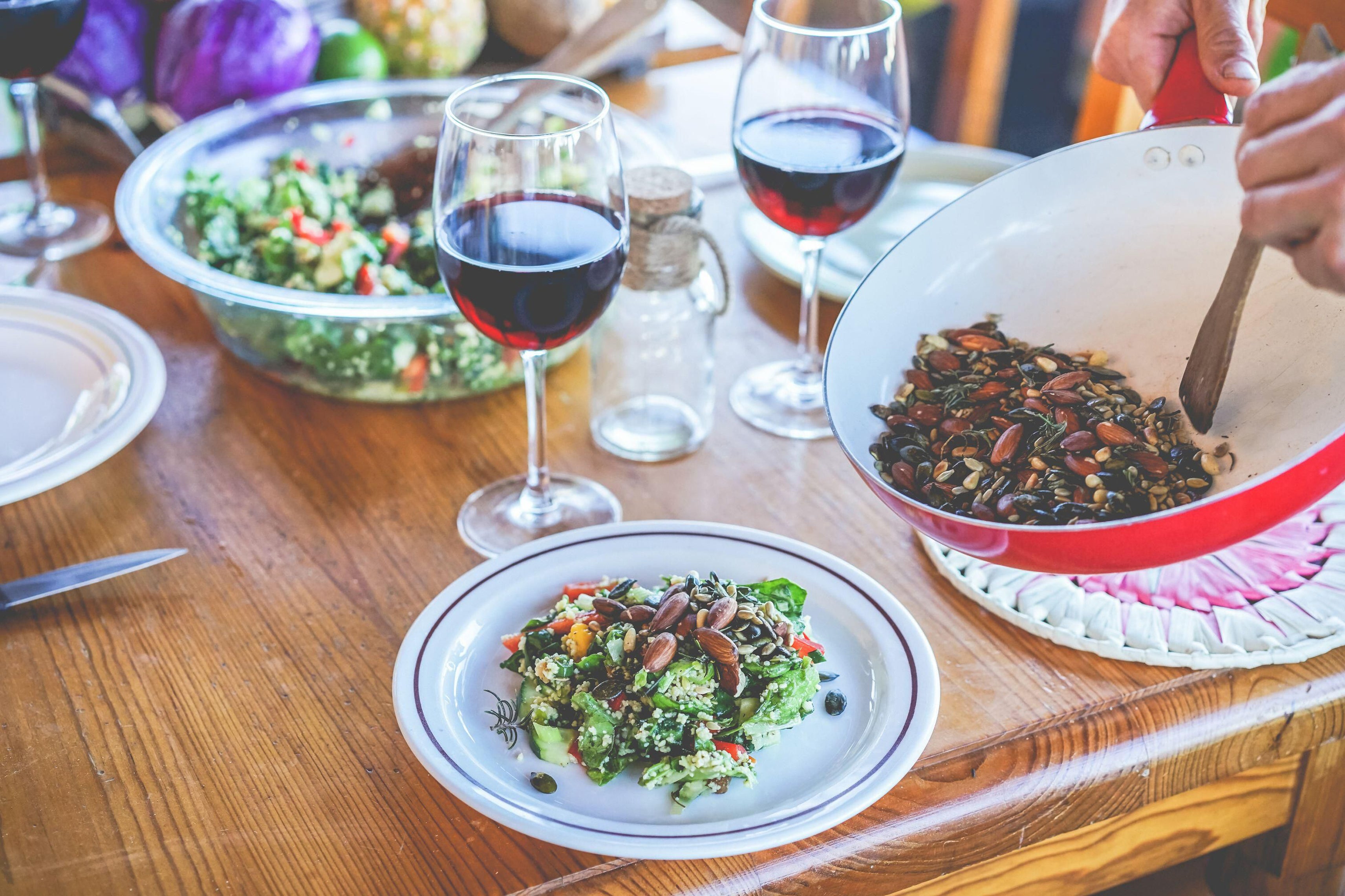 Man serving organic vegan salad with wine