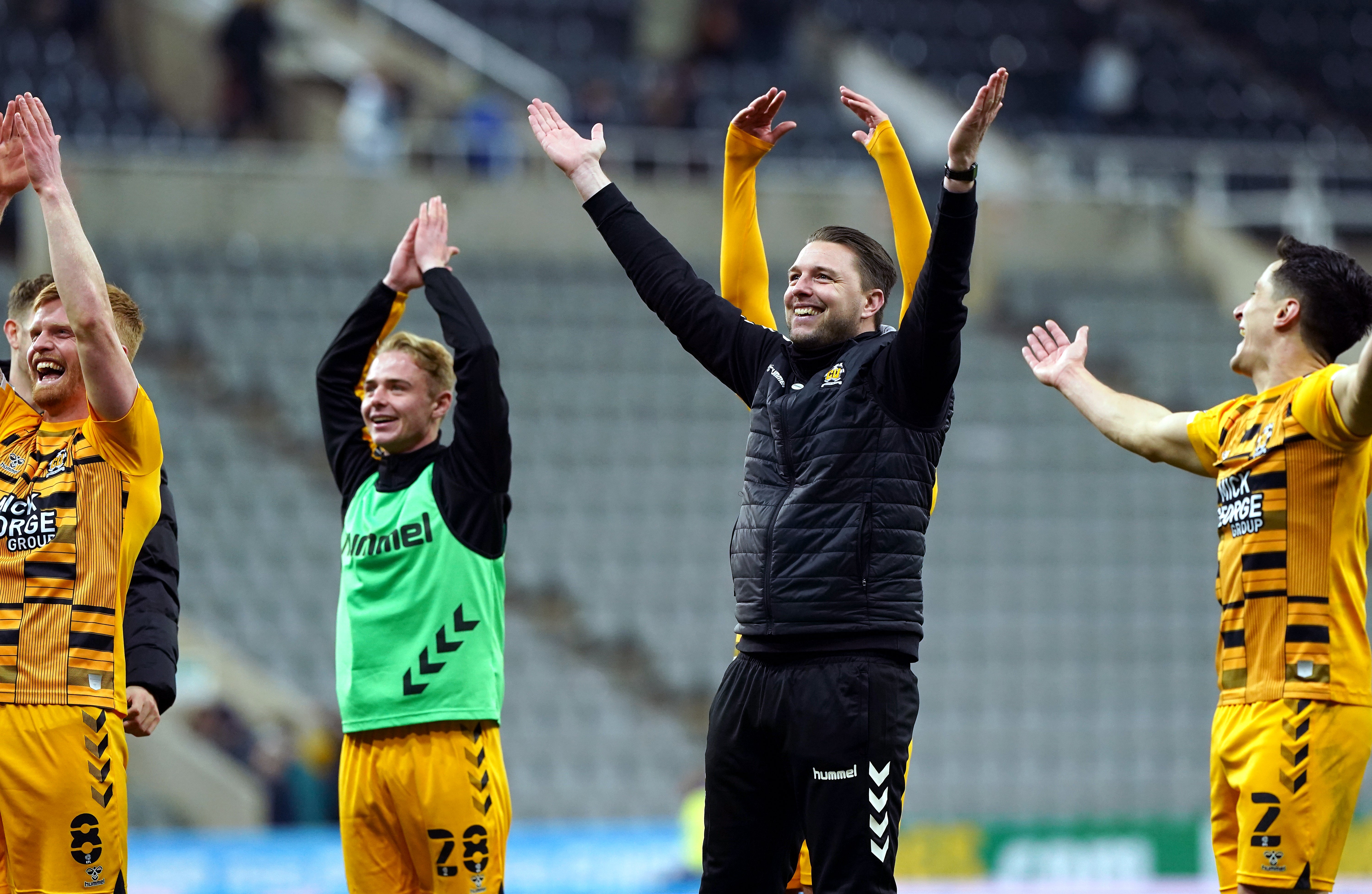 Cambridge United manager Mark Bonner (centre) celebrates with players after their shock win over Newcastle (Owen Humphreys/PA)