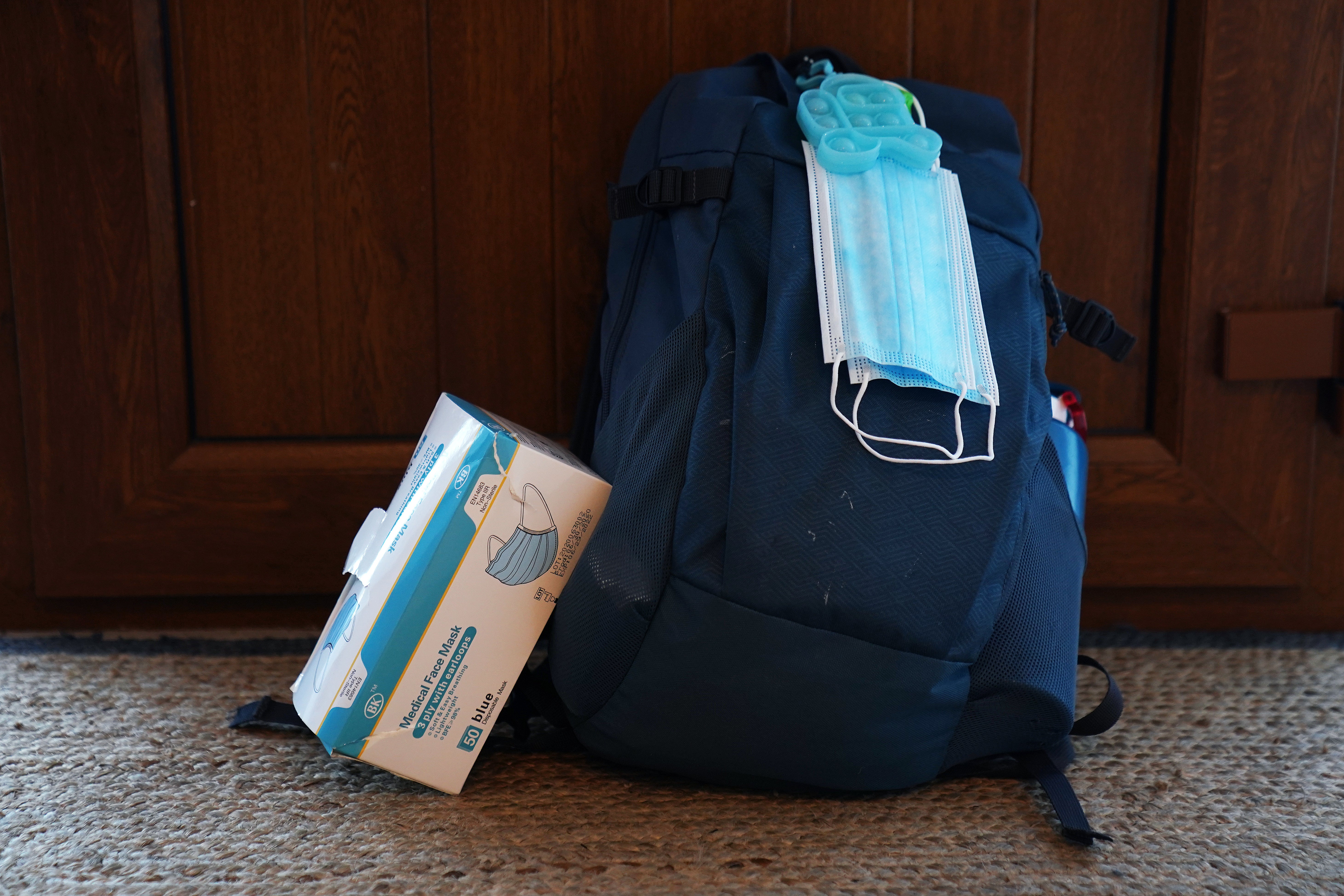 Face masks with a child’s schoolbag (Brian Lawless/PA)