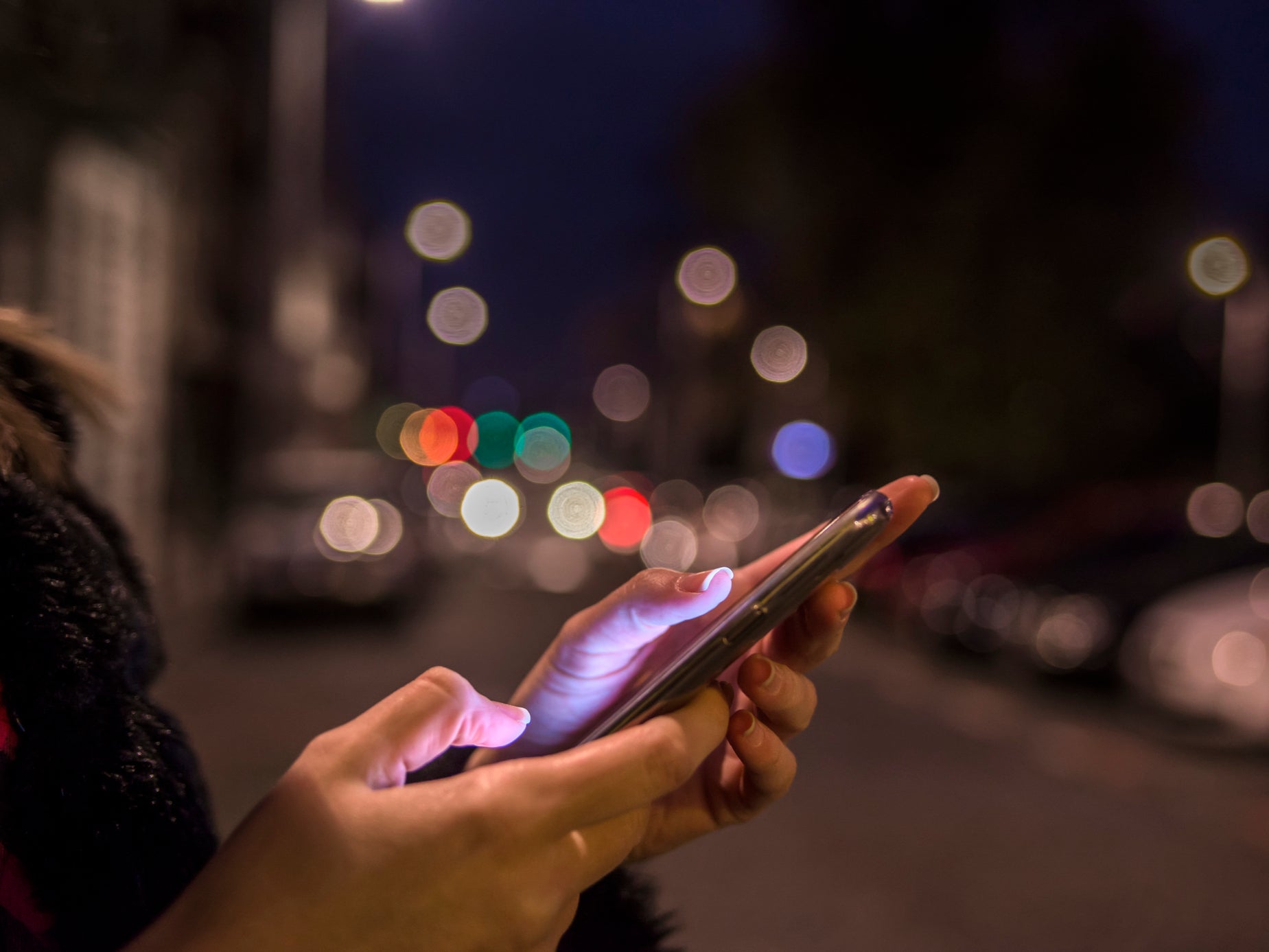 A woman uses her phone while travelling at night