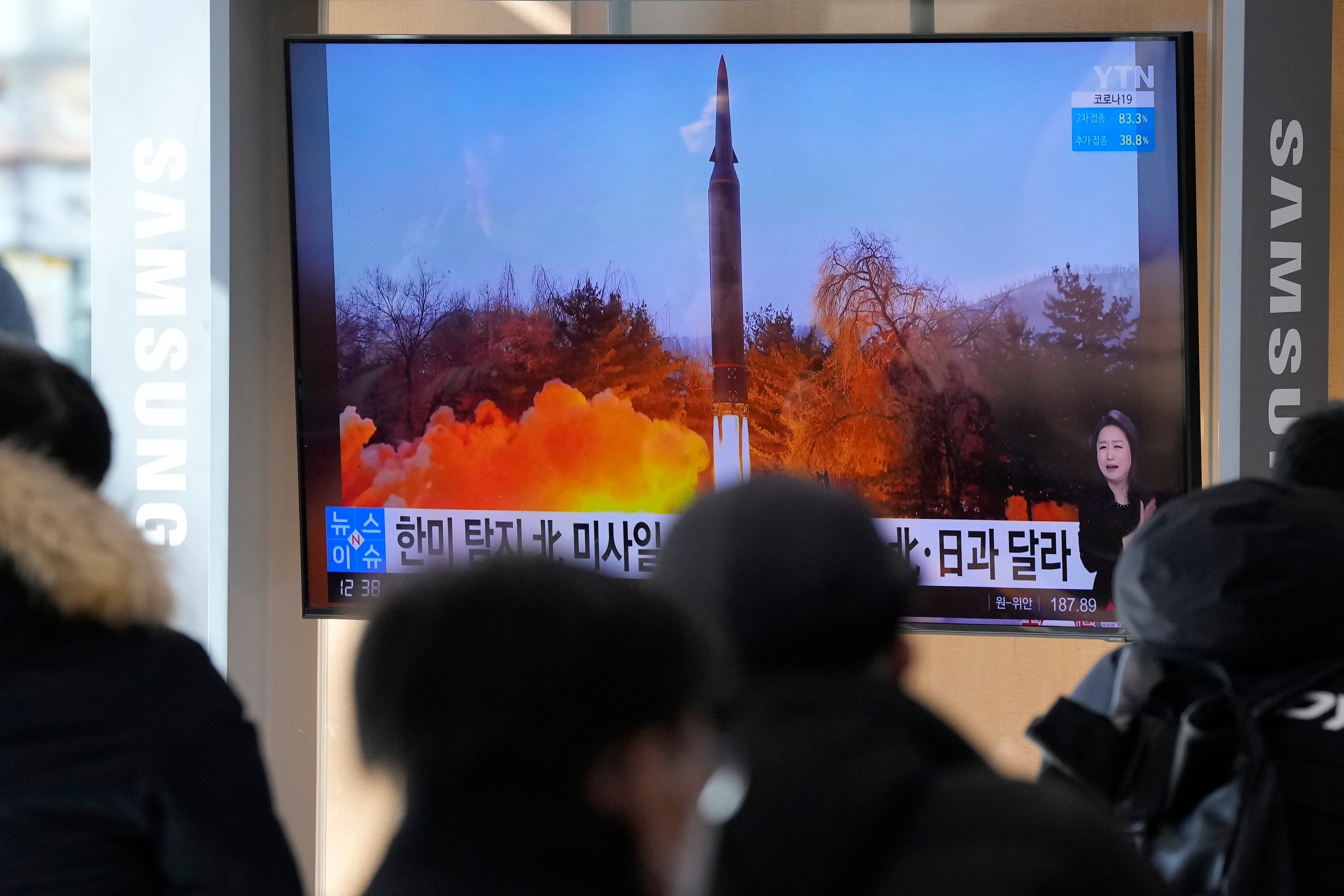 People watch a TV showing an image of North Korea’s missile launch during a news program at the Seoul Railway Station.