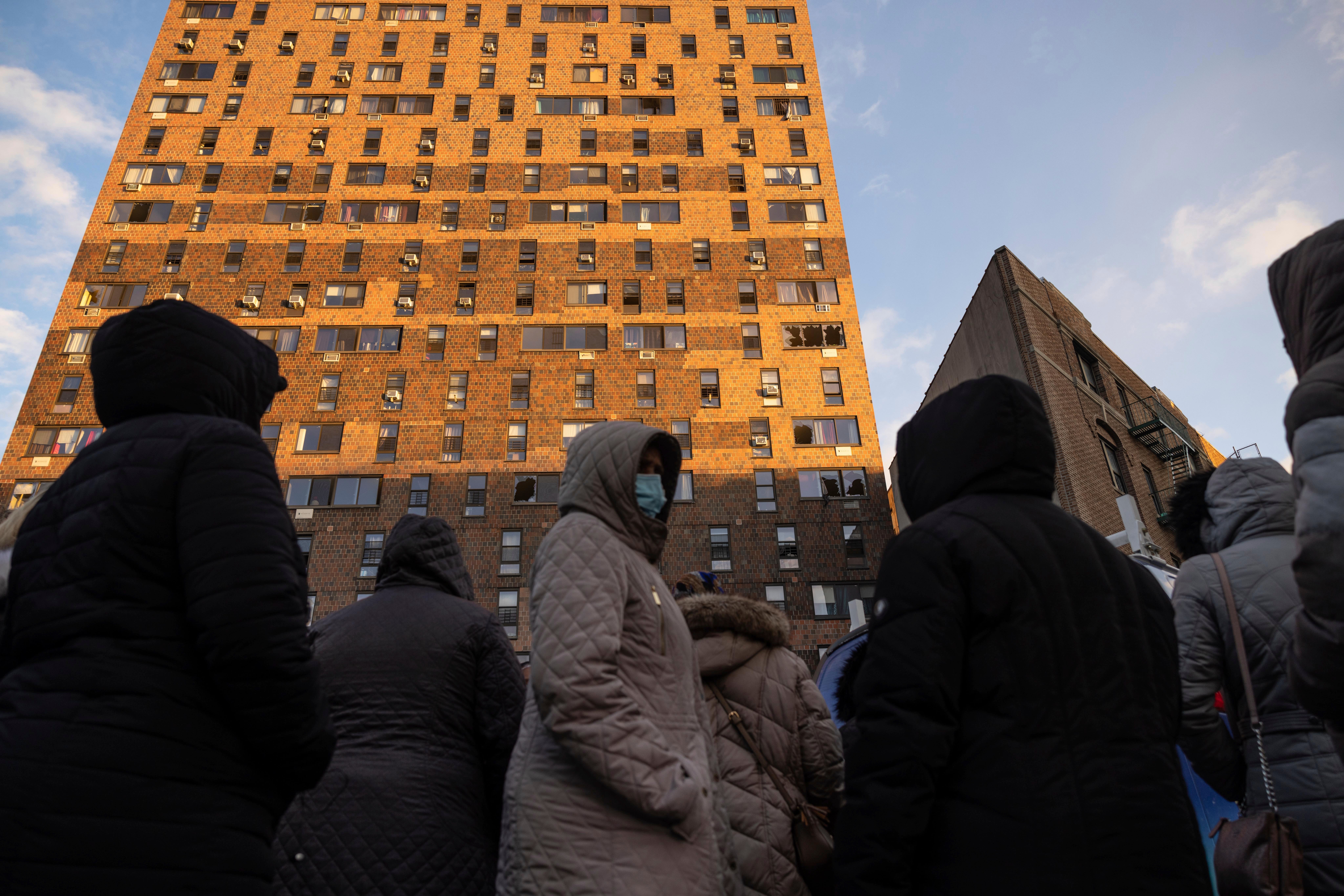 Residents of the apartment building which suffered the city's deadliest fire in three decades, gather outside the building to collect their belongings