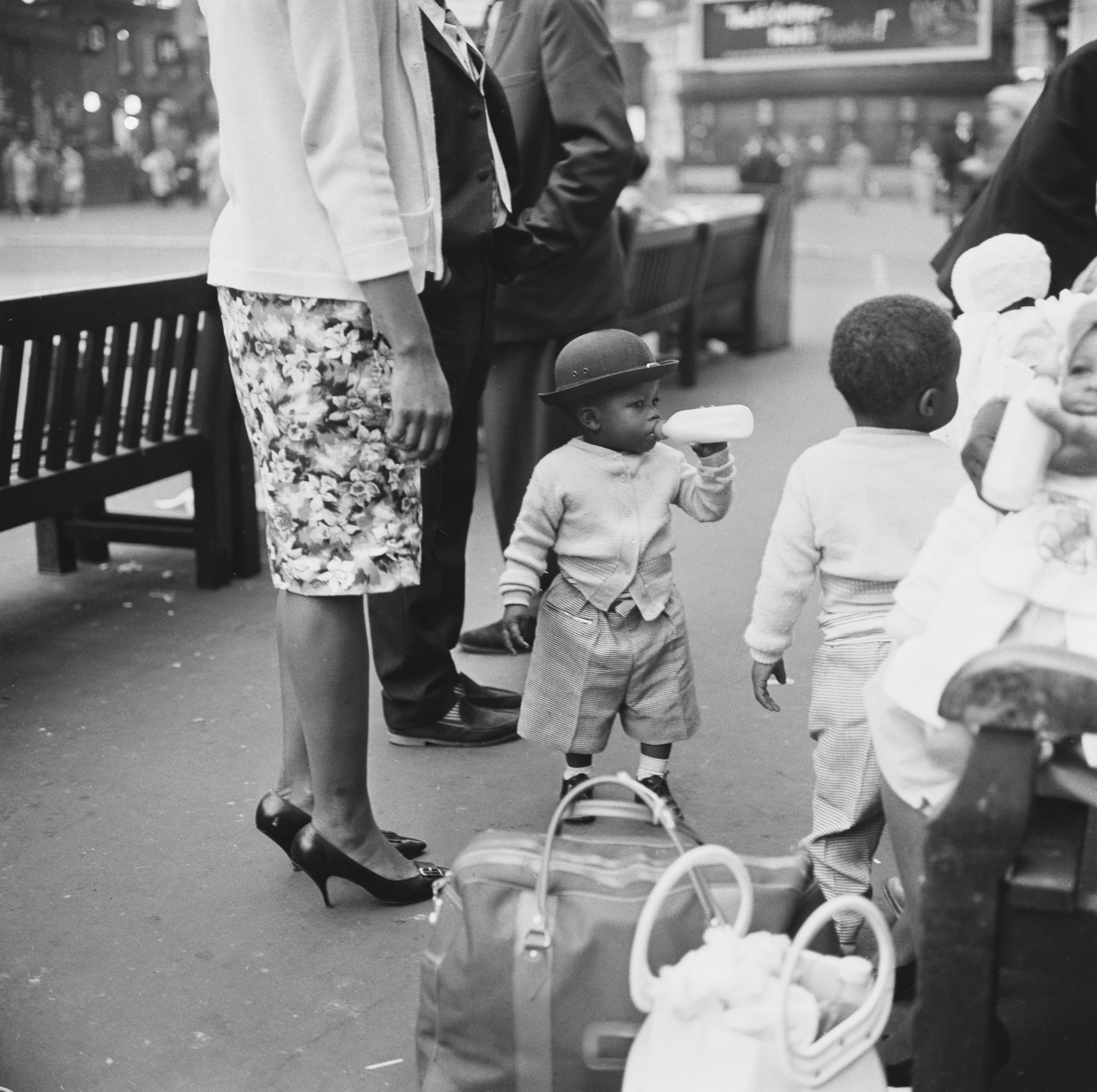 A child drinks milk as he waits to leave the UK in 1961 and return to the West Indies