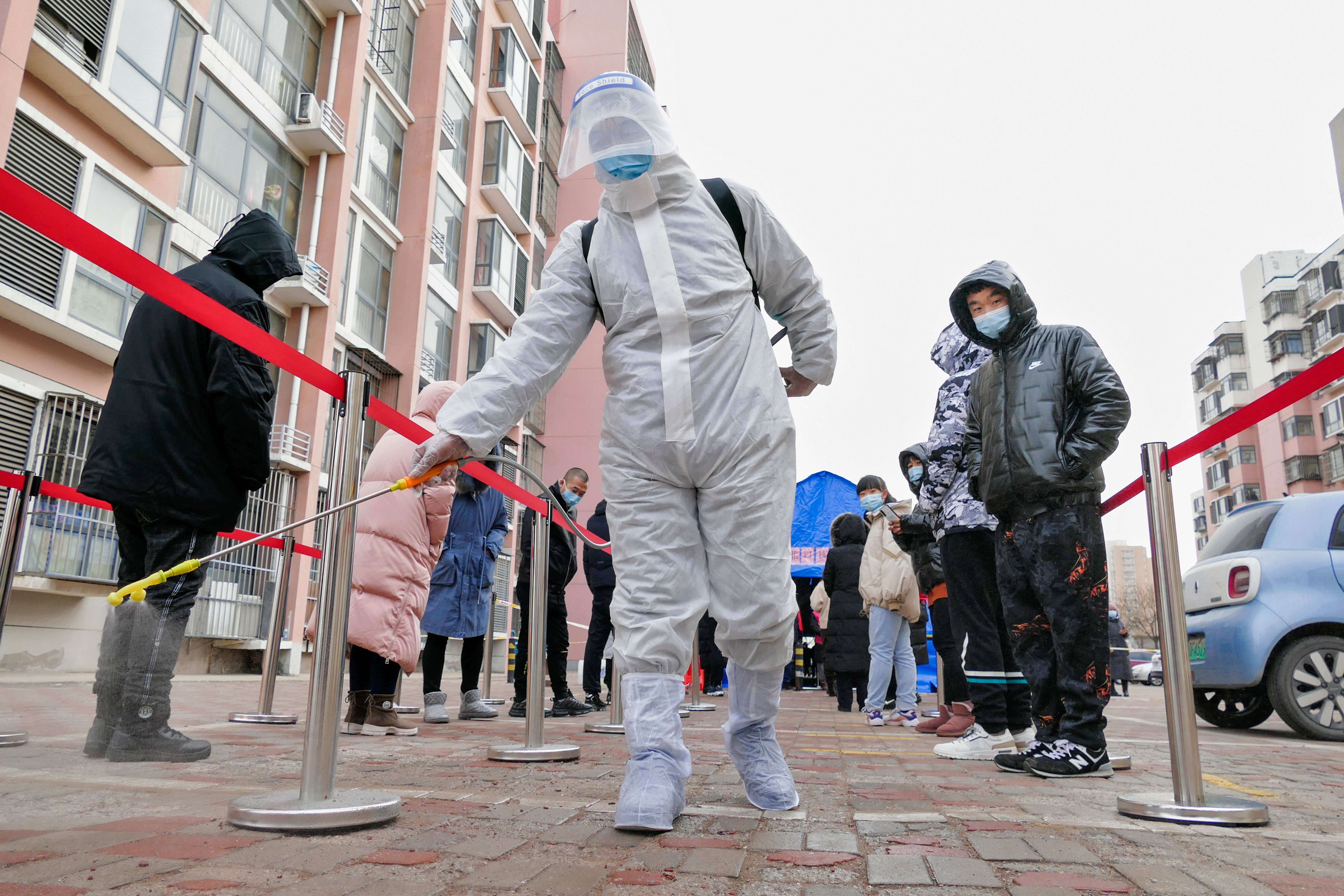 File photo: A worker wearing a protection suit sprays disinfectant in Tianjin, China, 9 January 2022