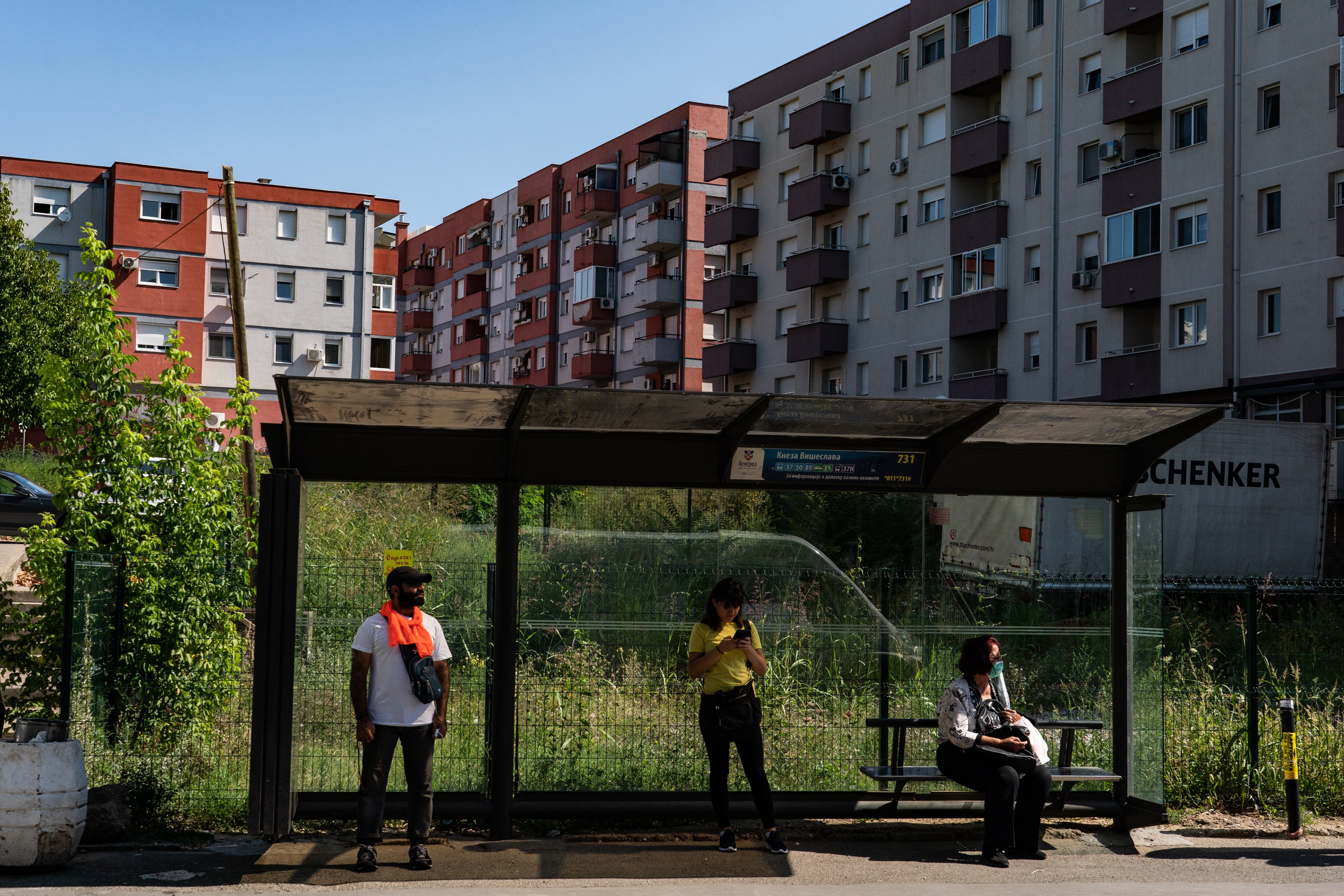 Adayfi waits for a bus, his orange scarf a reference to his time as a prisoner