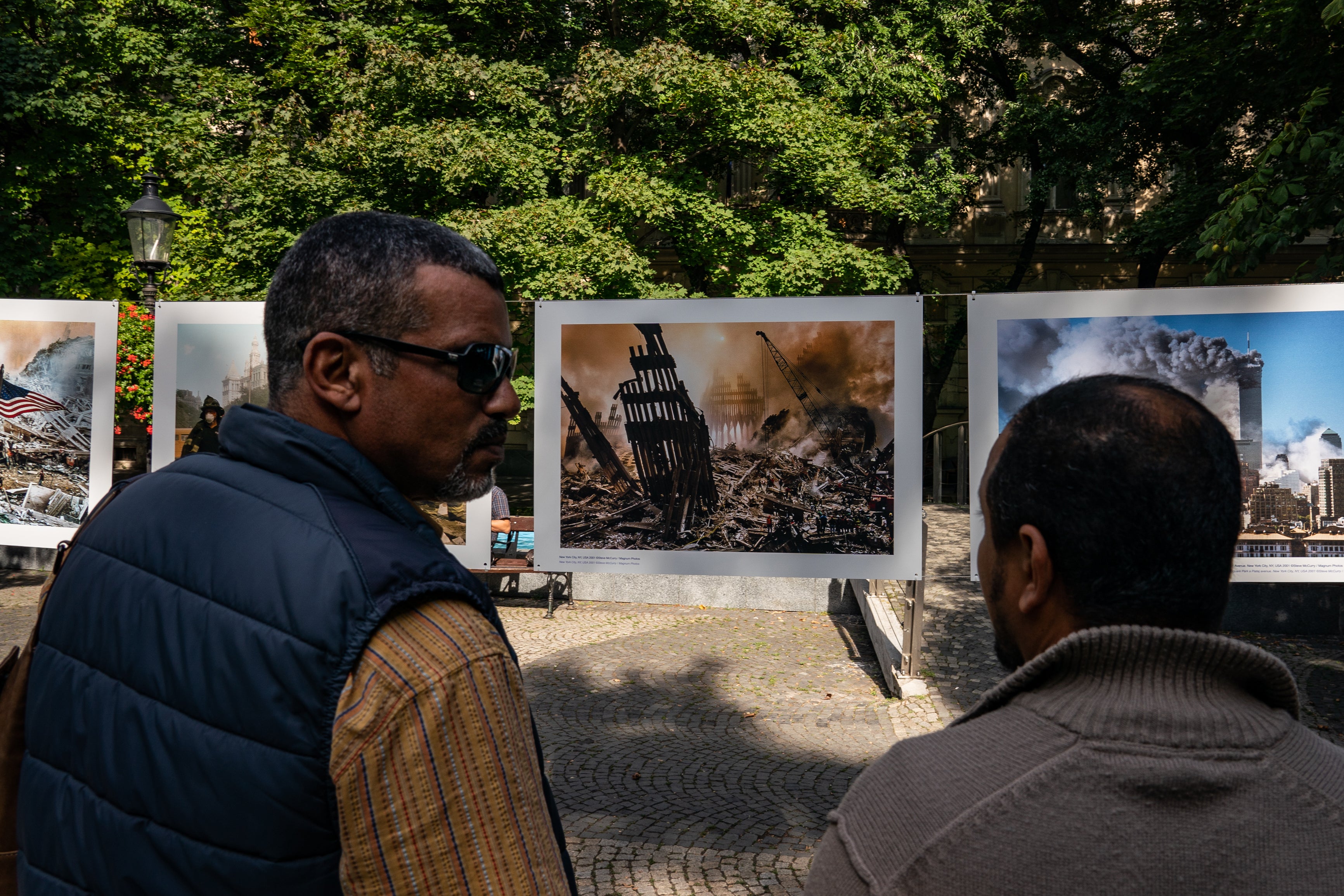 Sliti (left) and Hussein Almerfedi stop to look at a photo exhibit about 9/11 outside the US Embassy in Bratislava