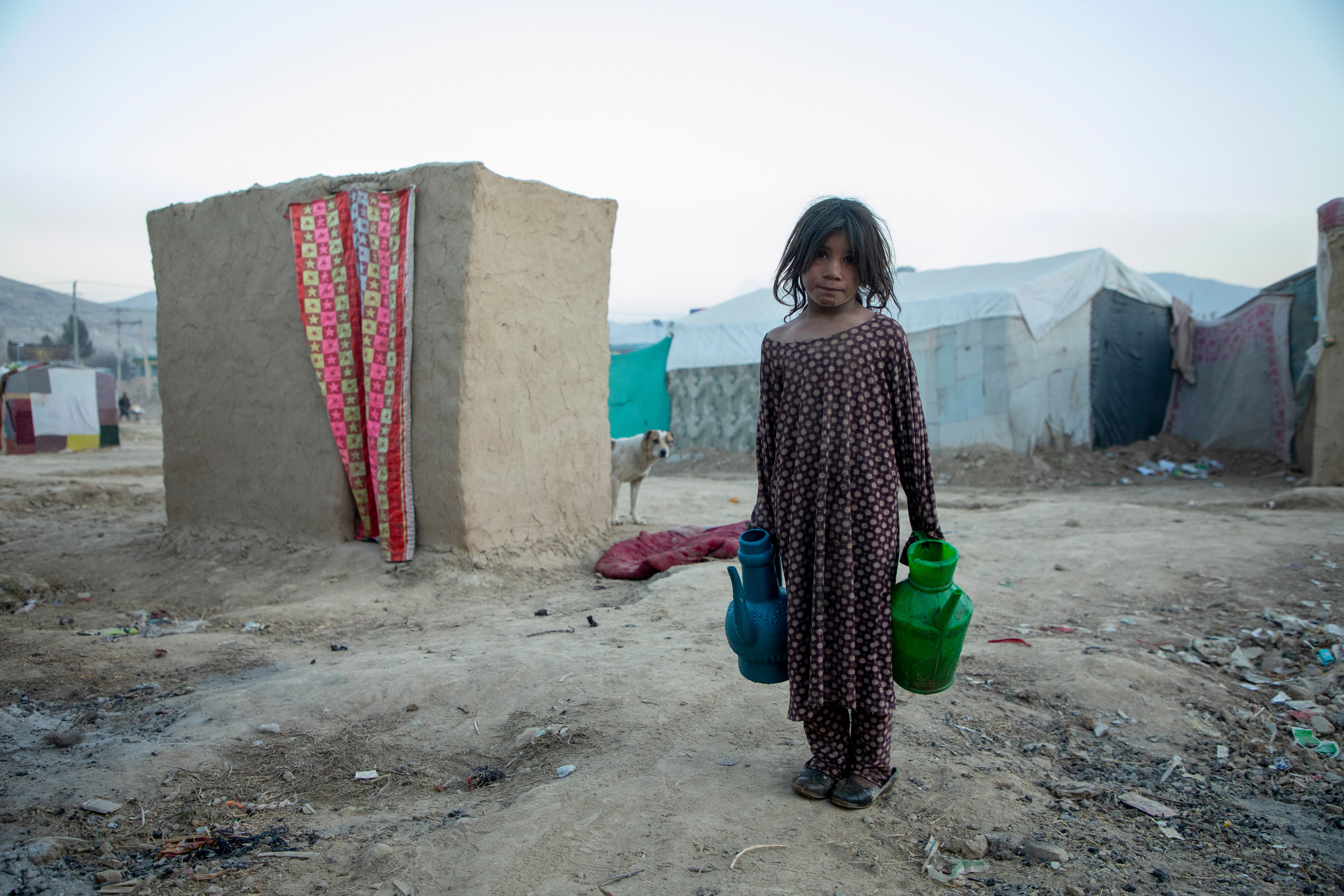 A girl collects water in IDP camp in northeast Afghanistan