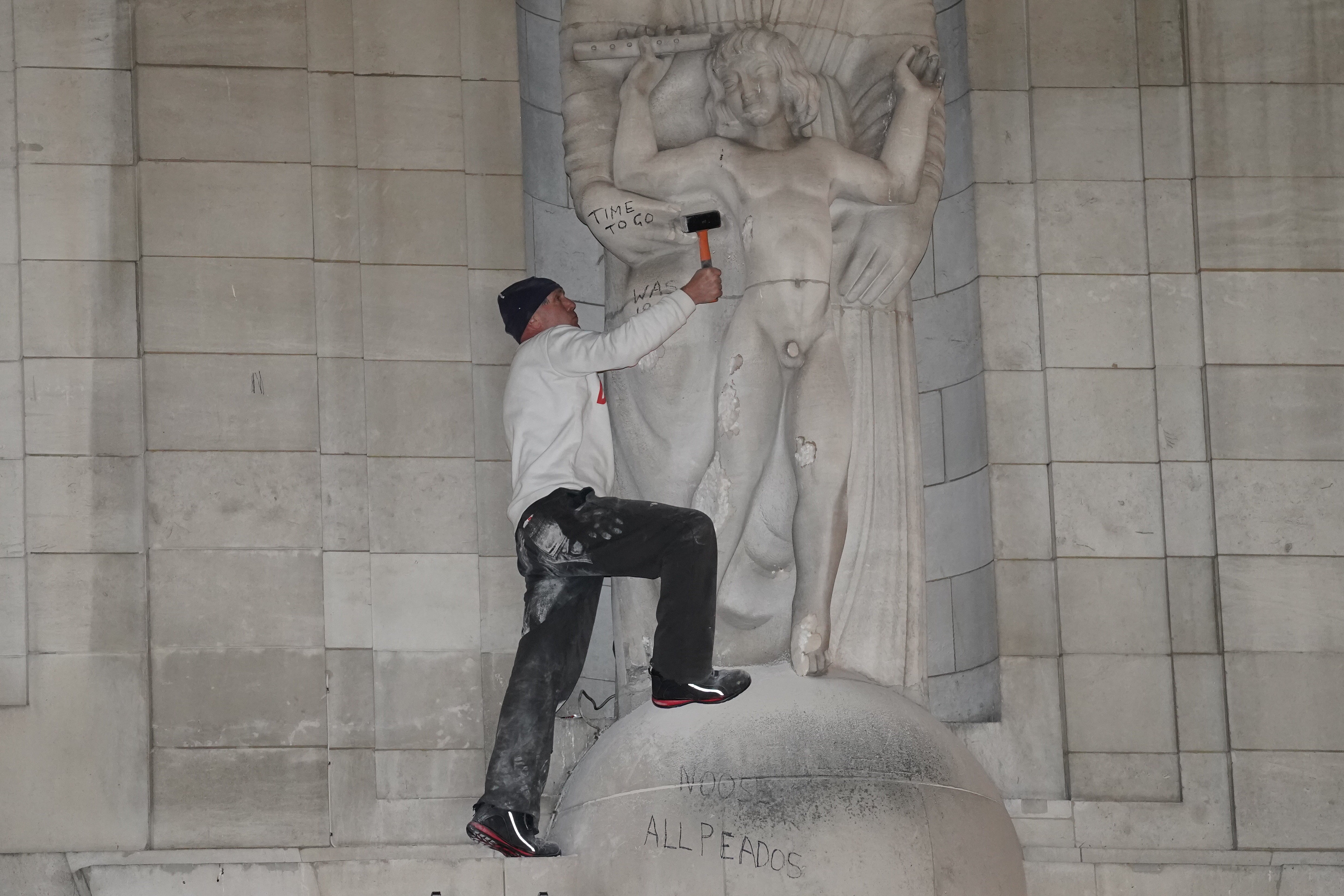 A man after he climbed onto the statues Prospero and Ariel statue from Shakespeare’s play (Ian West/PA)