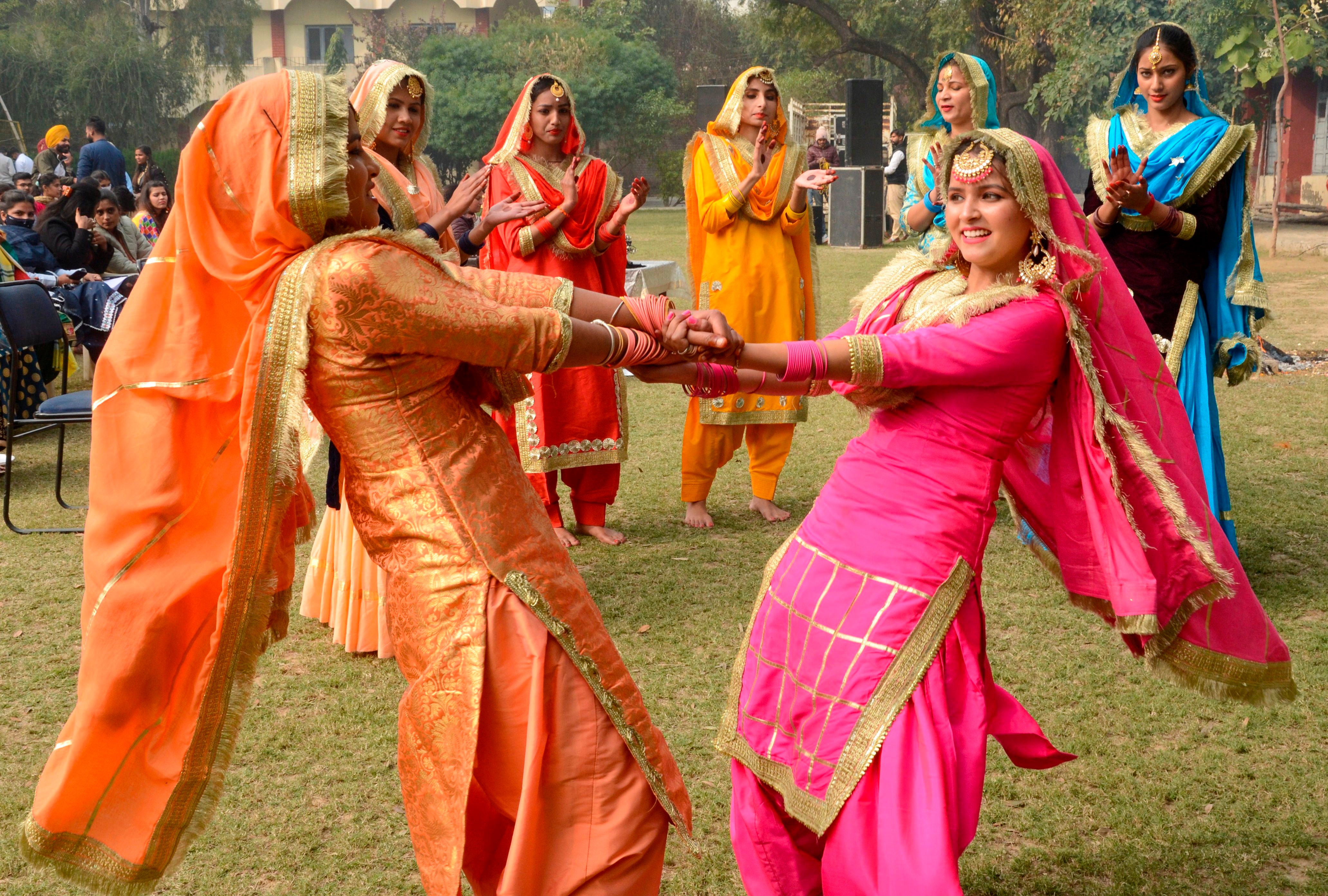 Students wearing traditional Punjabi outfits perform a folk dance to celebrate Lohri