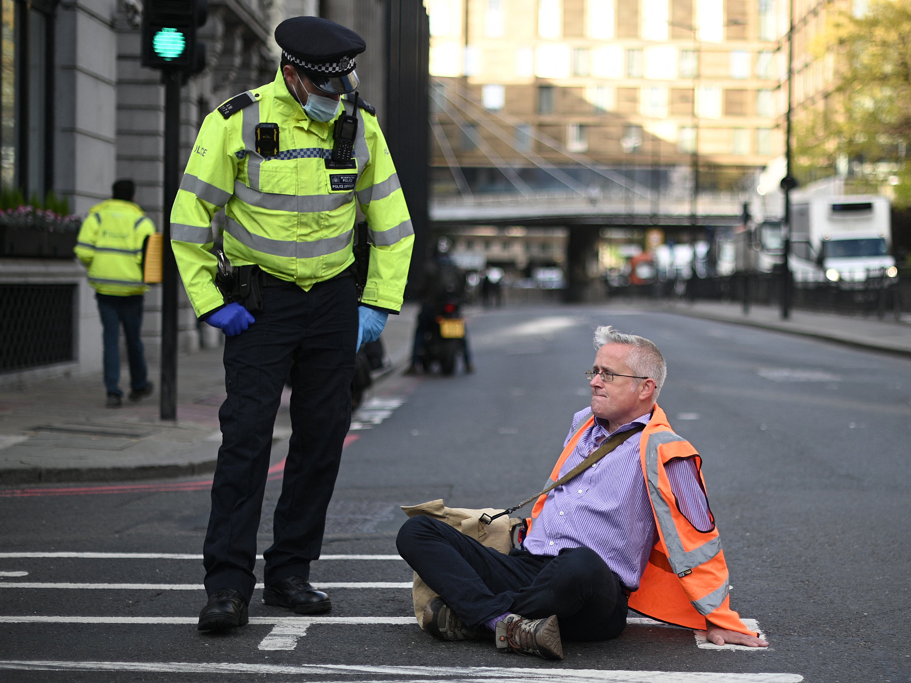 Biff Whipster blocks a street in central London with his hands glued to the road