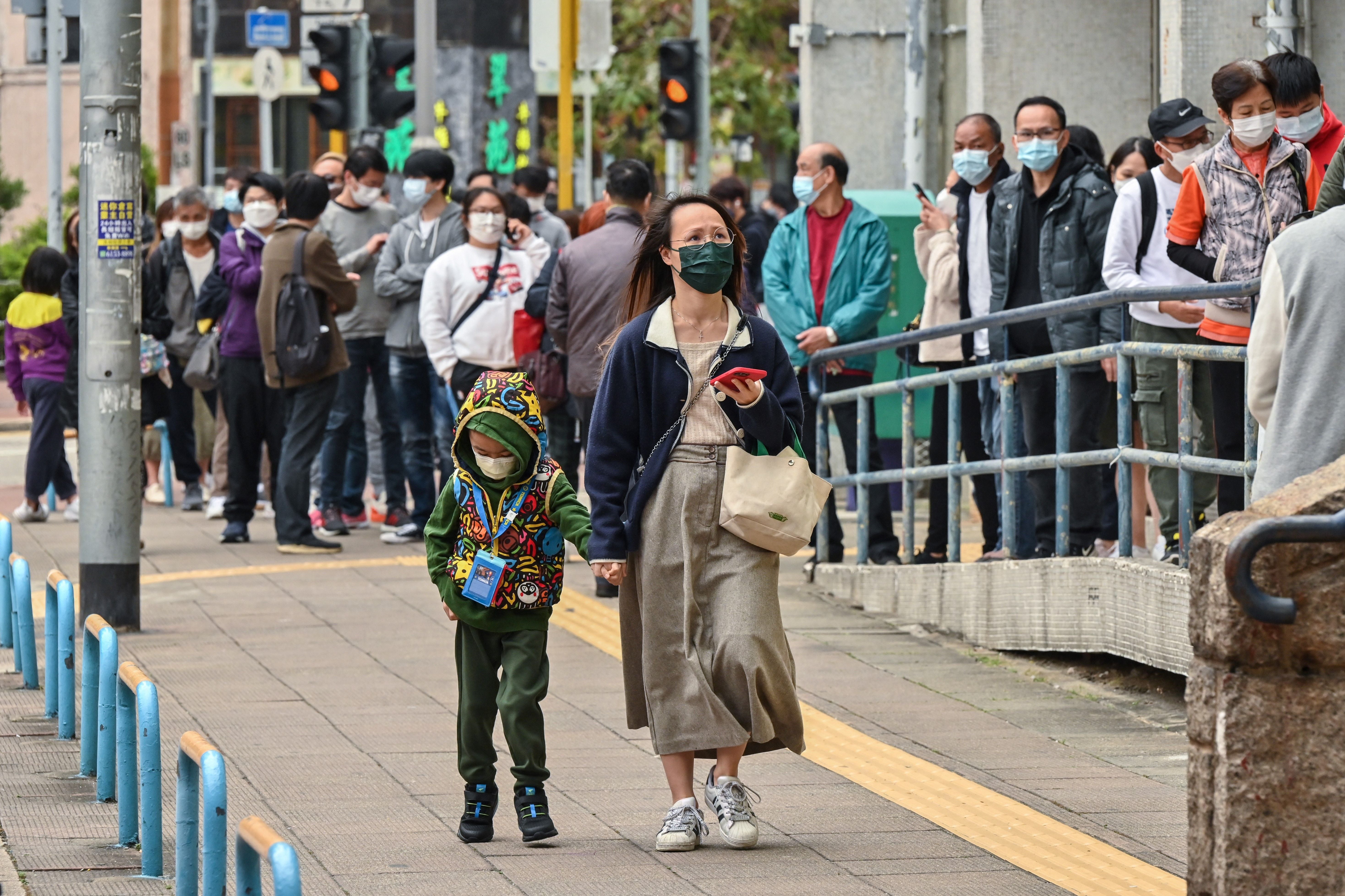 People queue up for Covid-19 tests in the Tuen Mun district of Hong Kong on 12 January