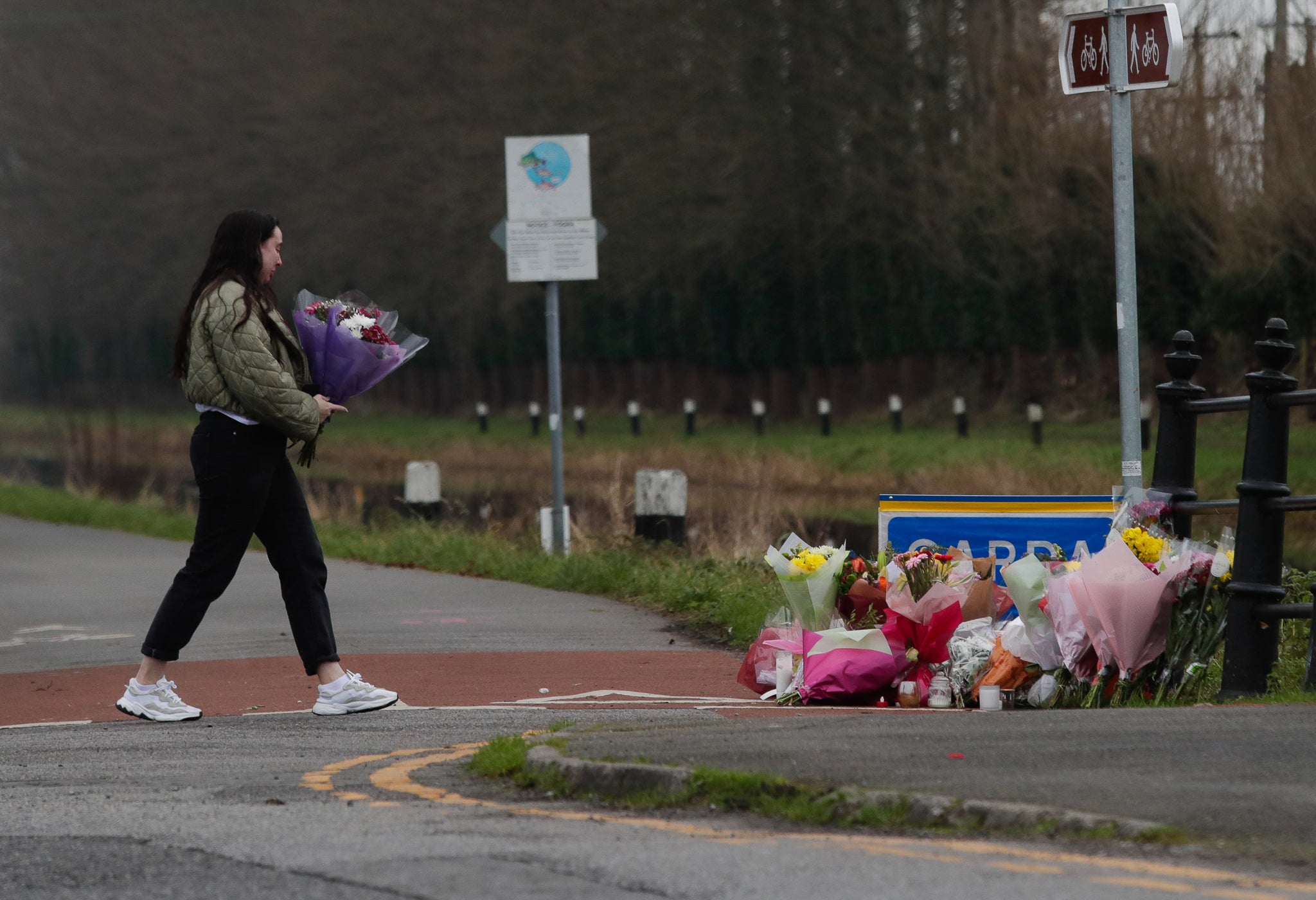 A woman lays flowers near the Grand Canal in Tullamore (Damien Eagers/PA)