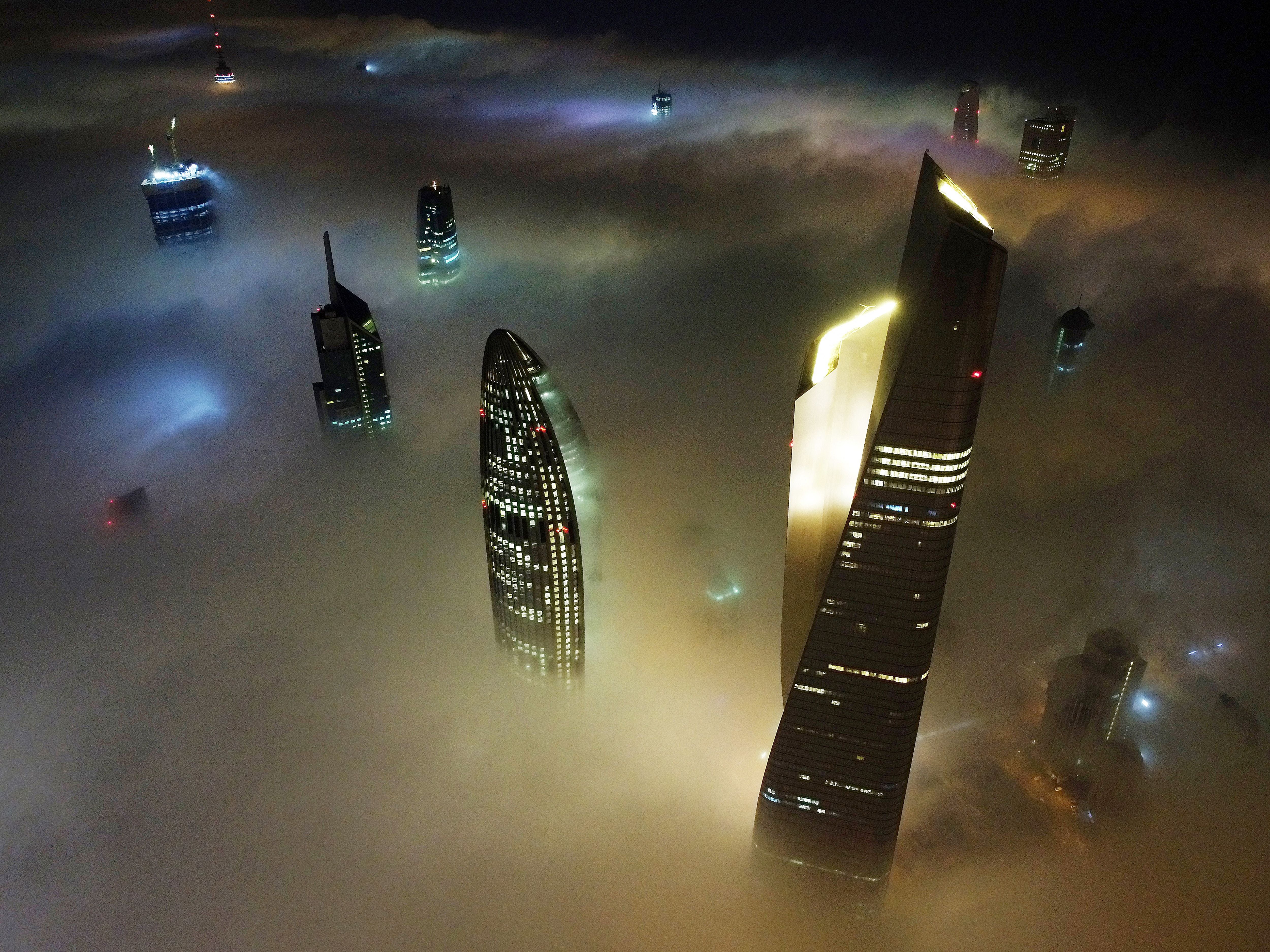 Kuwait City's al-Hamra tower (R), the headquarters of The National Bank of Kuwait (C) and the al-Rayah tower (L), caught in heavy fog