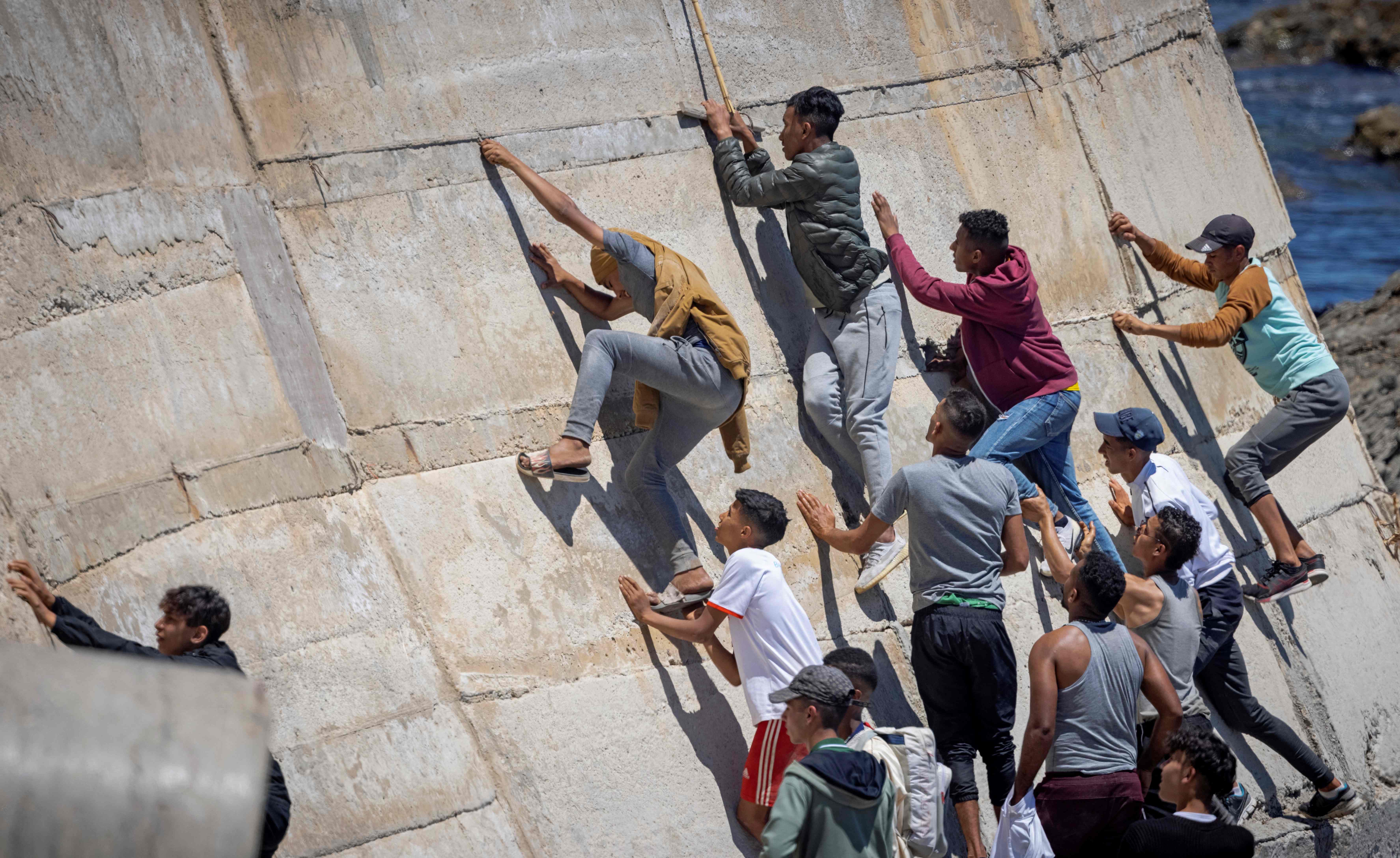 Migrants climb a sea wall in the northern Morocco town of Fnideq after attempting to cross the border to Spain’s north African enclave of Ceuta last May