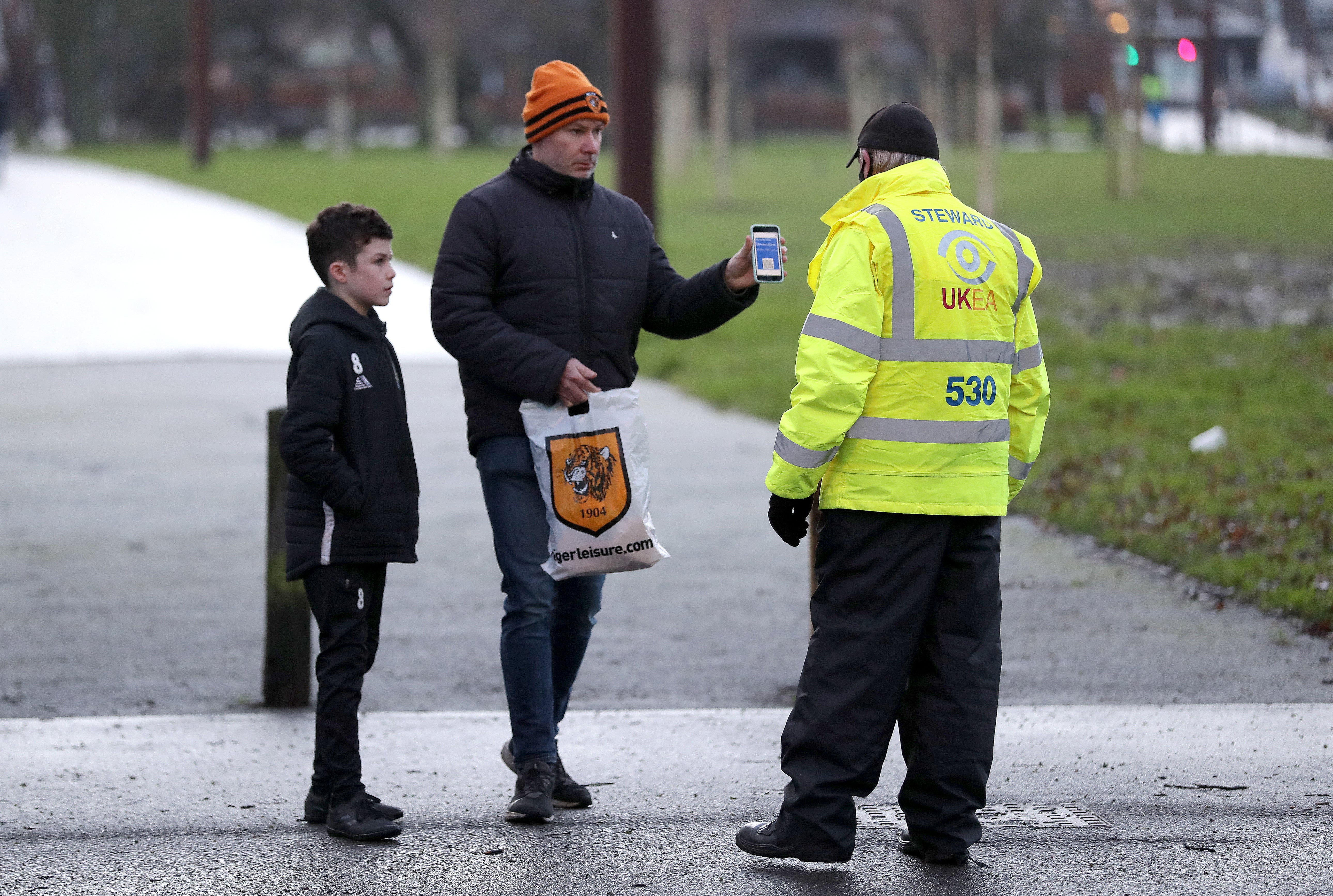 Fans show their Covid passports before an FA Cup match at the MKM Stadium, Hull (Richard Sellers/PA)