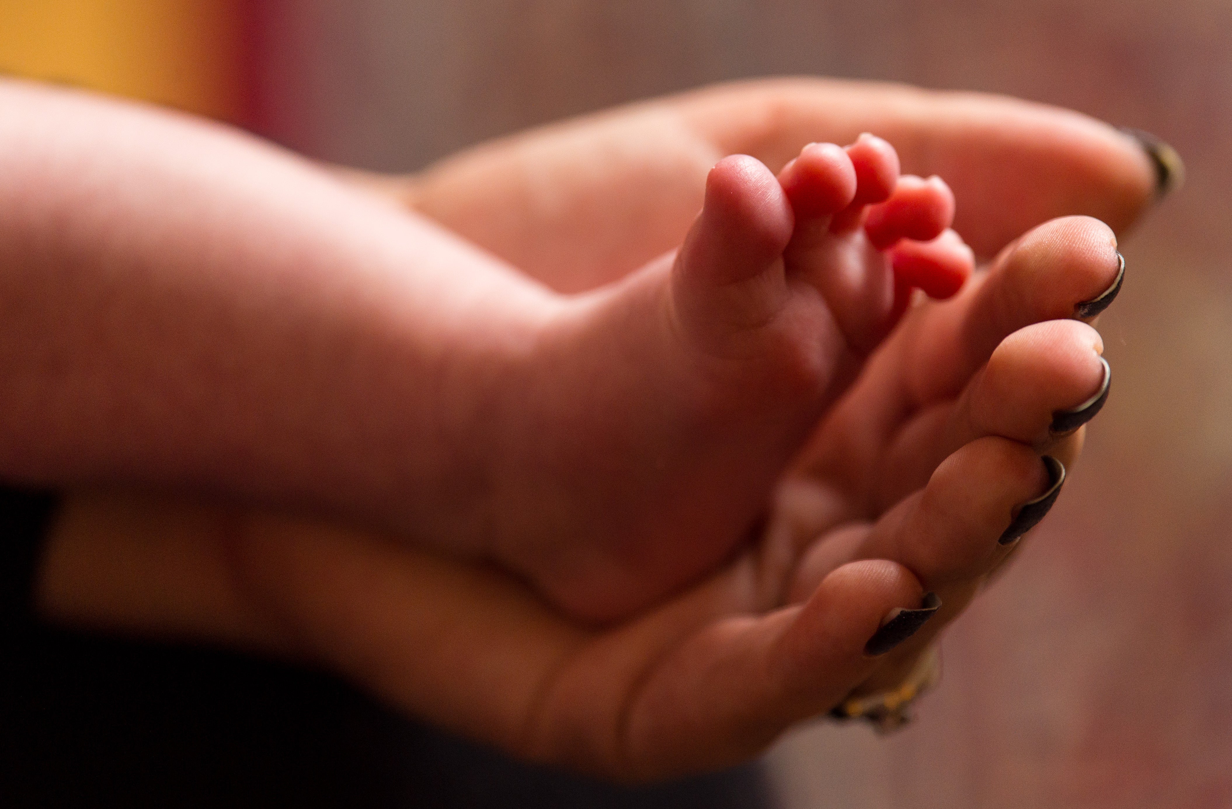 Undated file photo of a mother holding the feet of a new baby (Dominic Lipinski/PA)