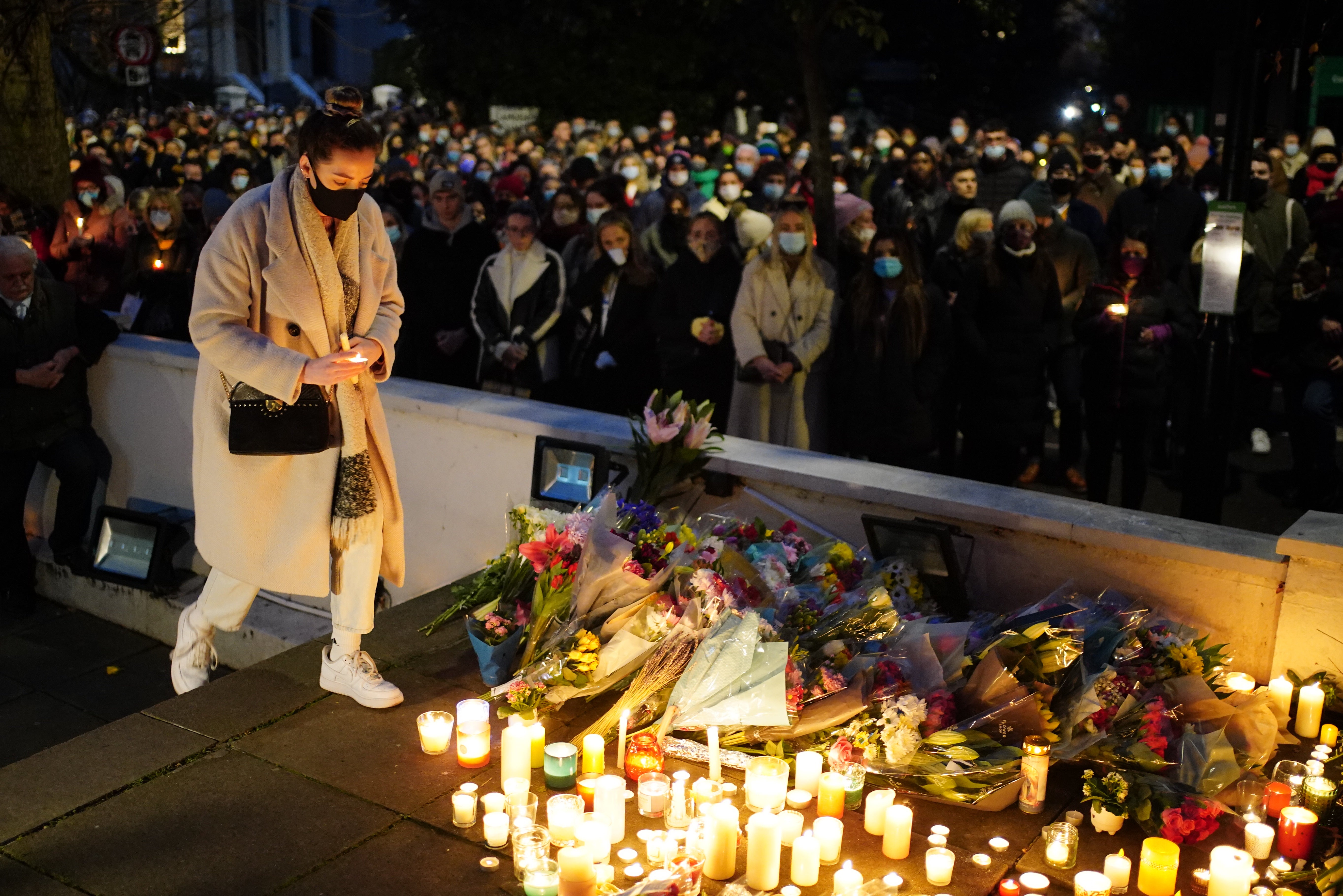 Floral tributes and candles are left after a vigil outside the London Irish Centre in Camden (Dominic Lipinski/PA)