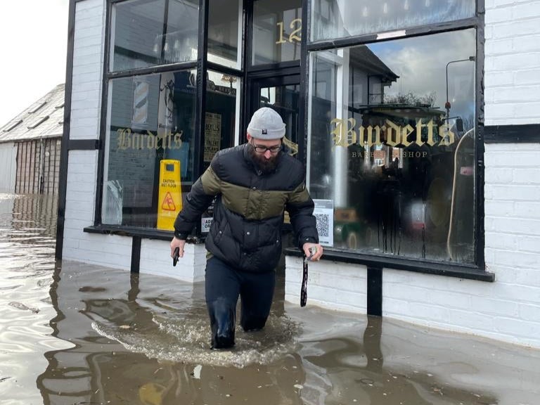 Brent Nile outside his barber shop during the flooding