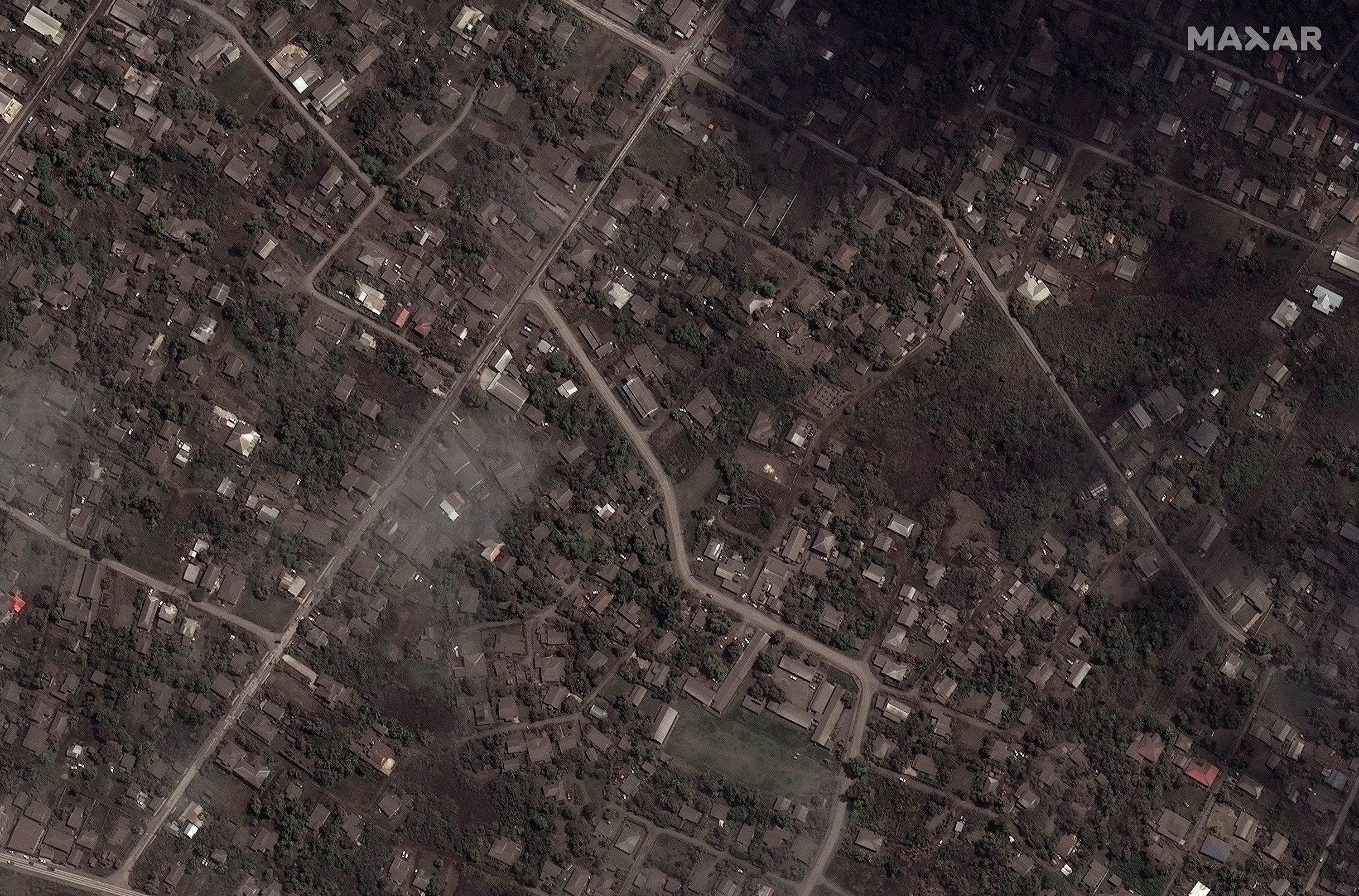 A satellite image shows ash-covered homes and buildings after the main eruption