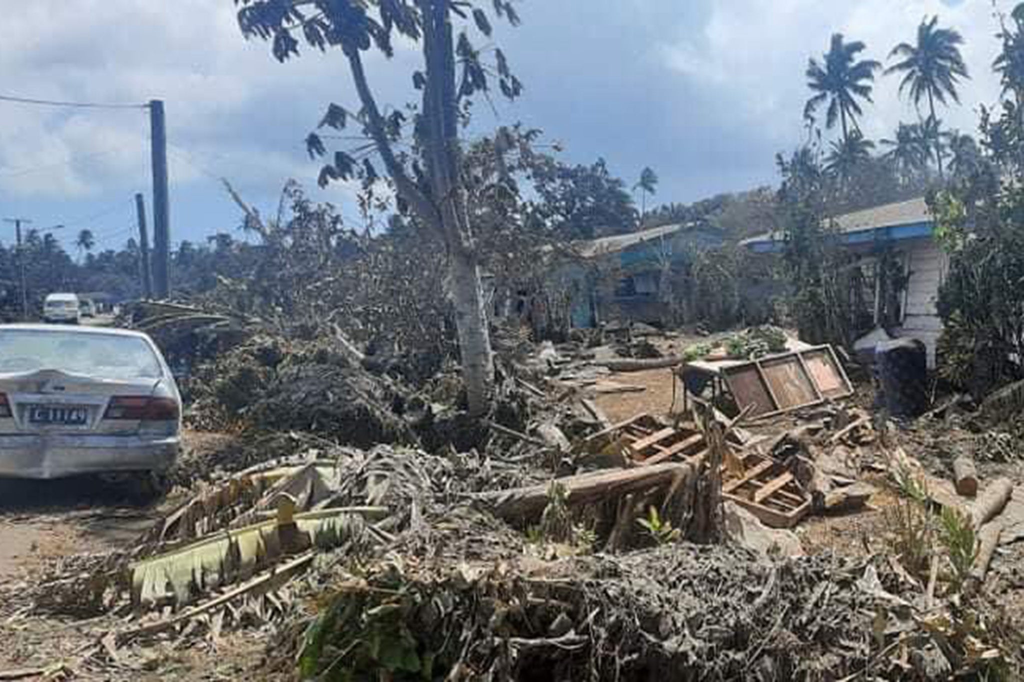 Fallen trees and household debris cover a residential area of Nuku’alofa