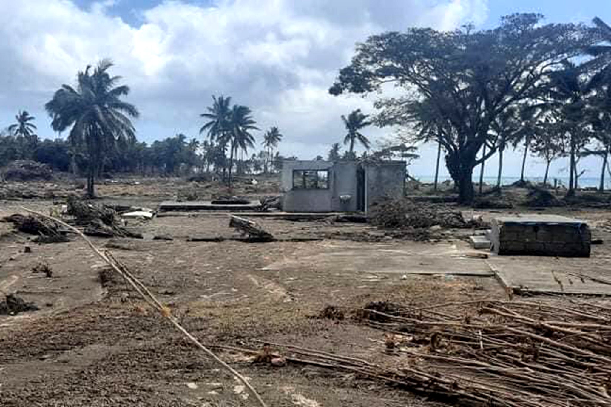 Parts of buildings on Tongaptu coast remain standing amid debris