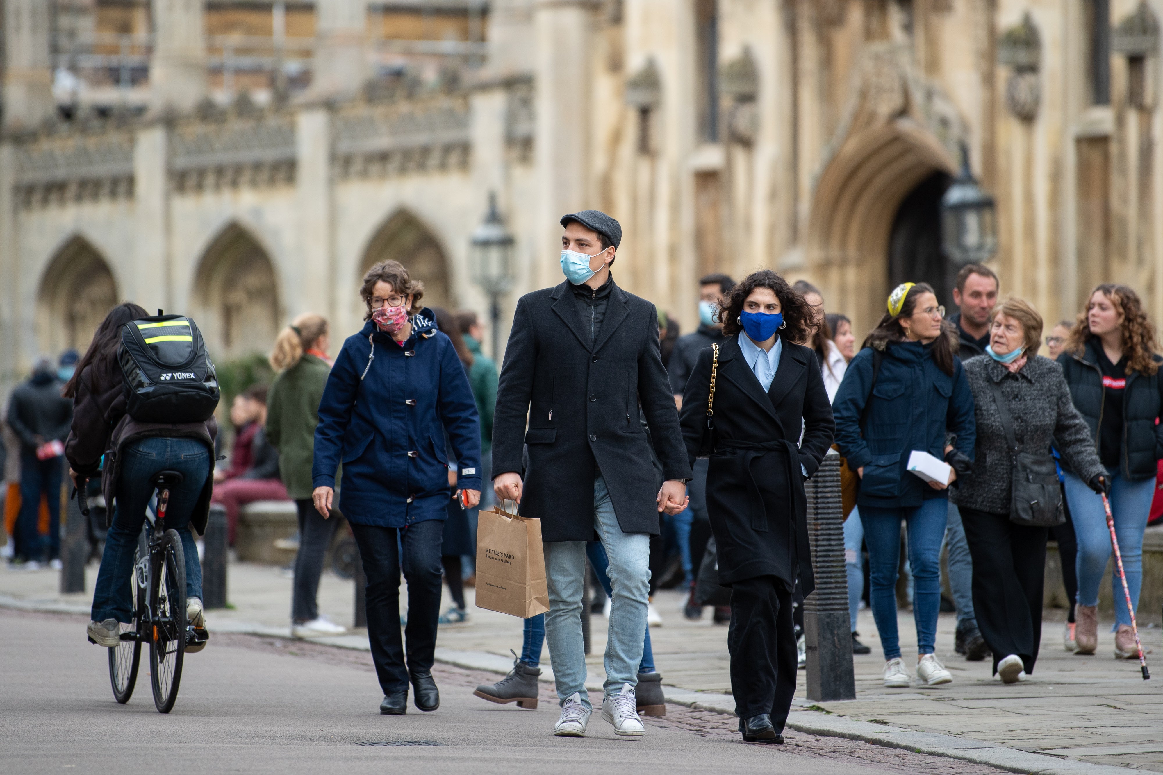 People wear face masks as they walk along Kings Parade in Cambridge (Joe Giddens/PA)