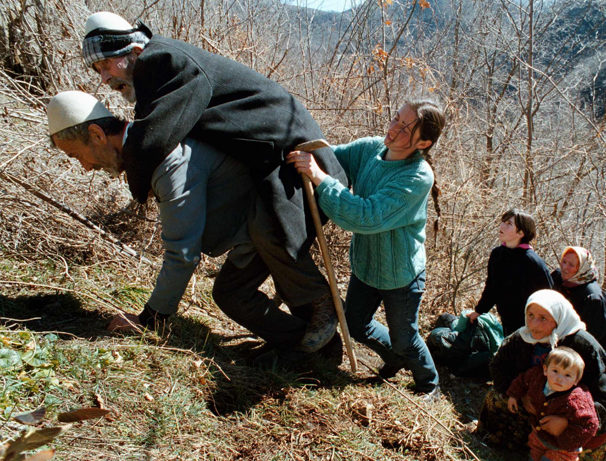 An ethnic Albanian man carries his father uphill in the mountains near Kacanik, about 60km south of Pristina, 9 March 1999