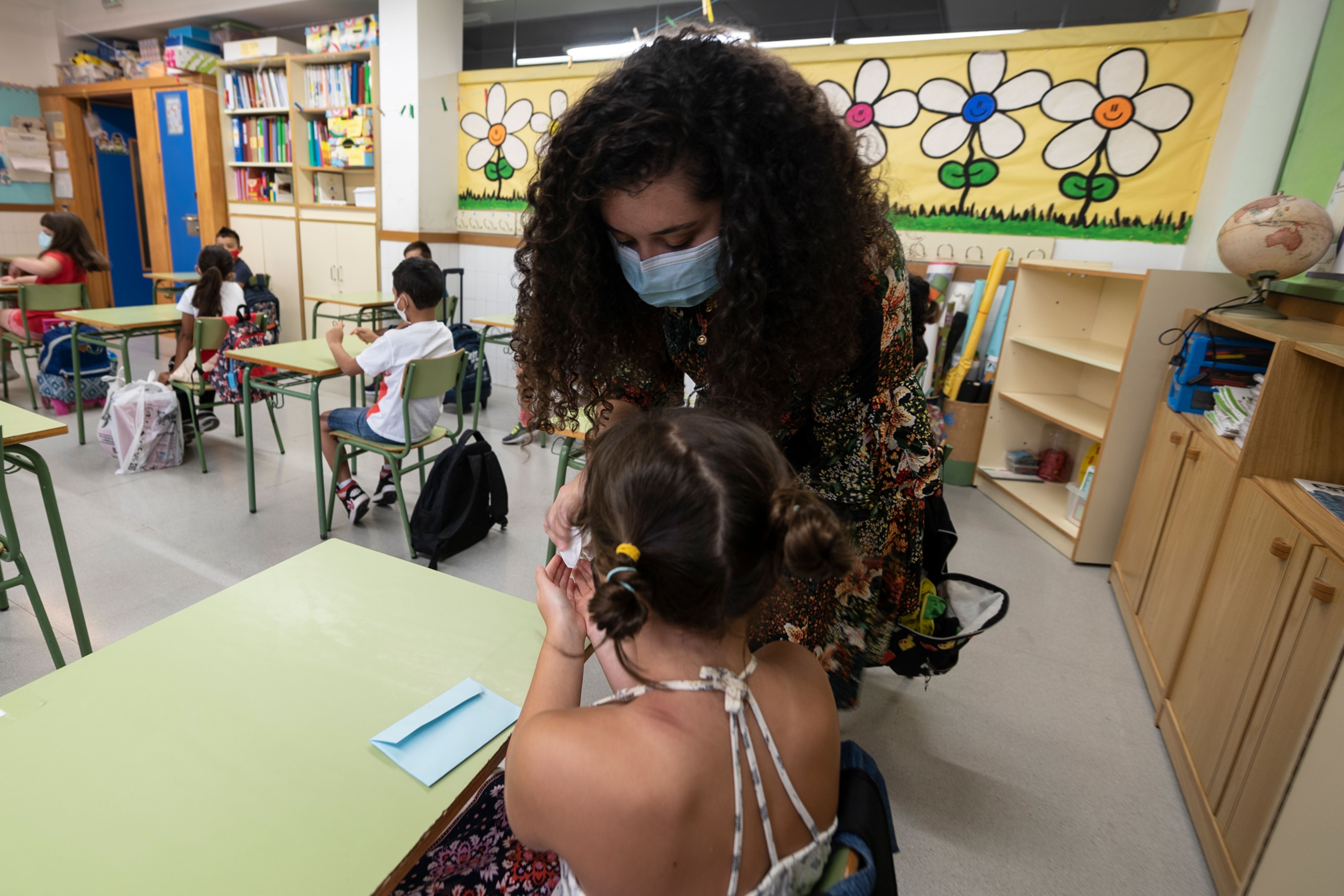 File photo: A teacher cleans a student’s hands with a hand sanitiser in Valencia on 7 September 2020