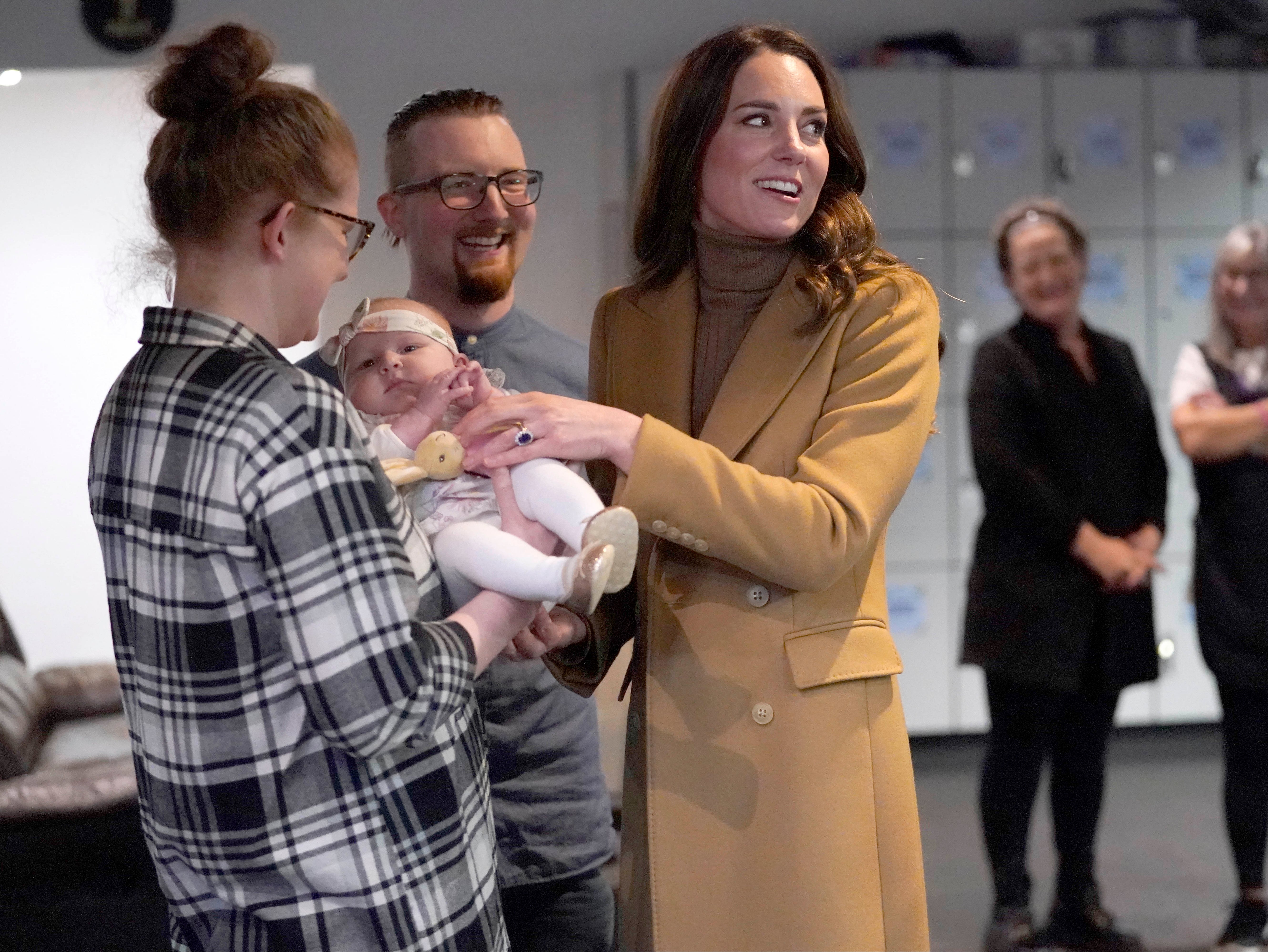 Catherine, Duchess of Cambridge (right) meets Trudi and Alastair Barrie and their daughter Anastasia during a visit to charity, Church on the Street