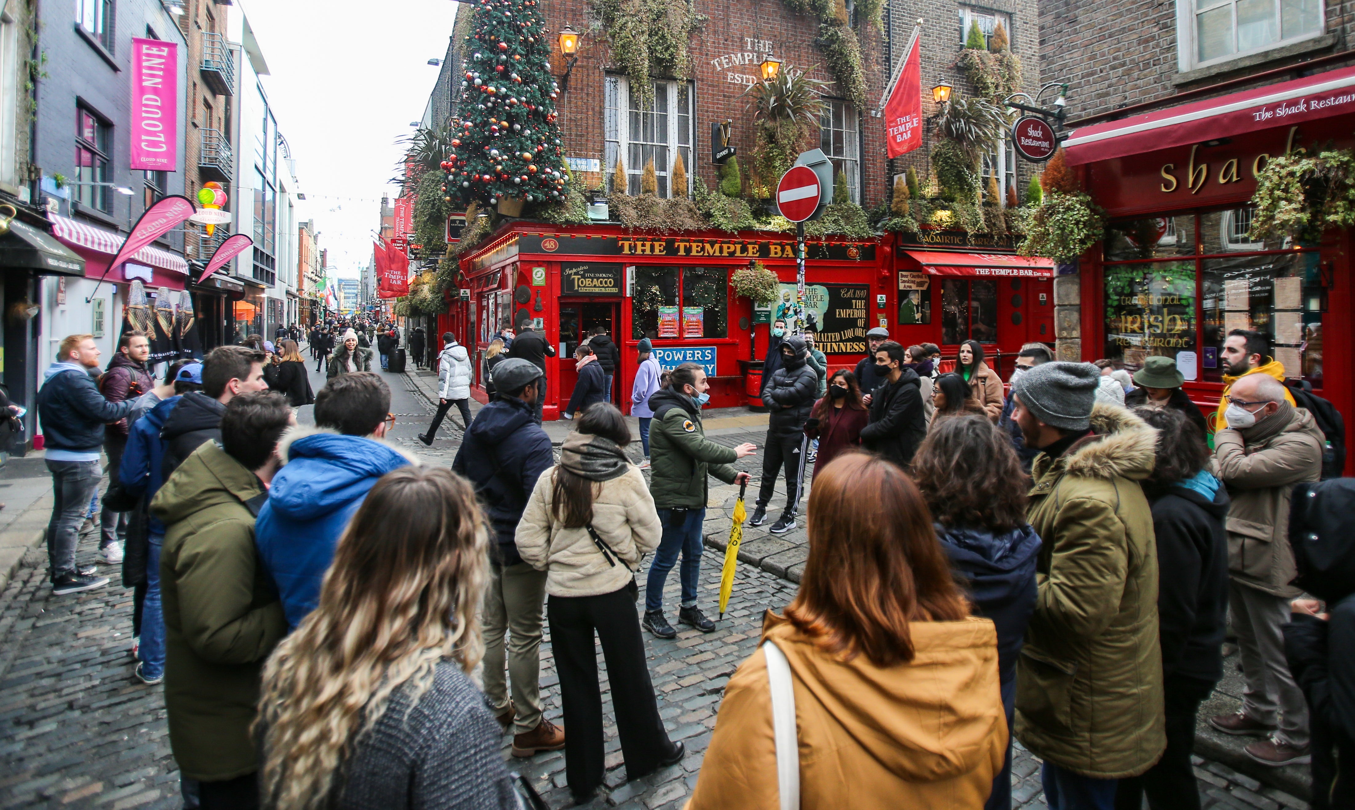 A tour group leader stops with tourists at the Temple Bar in Dublin on the day coronavirus restrictions were eased across Ireland (PA)