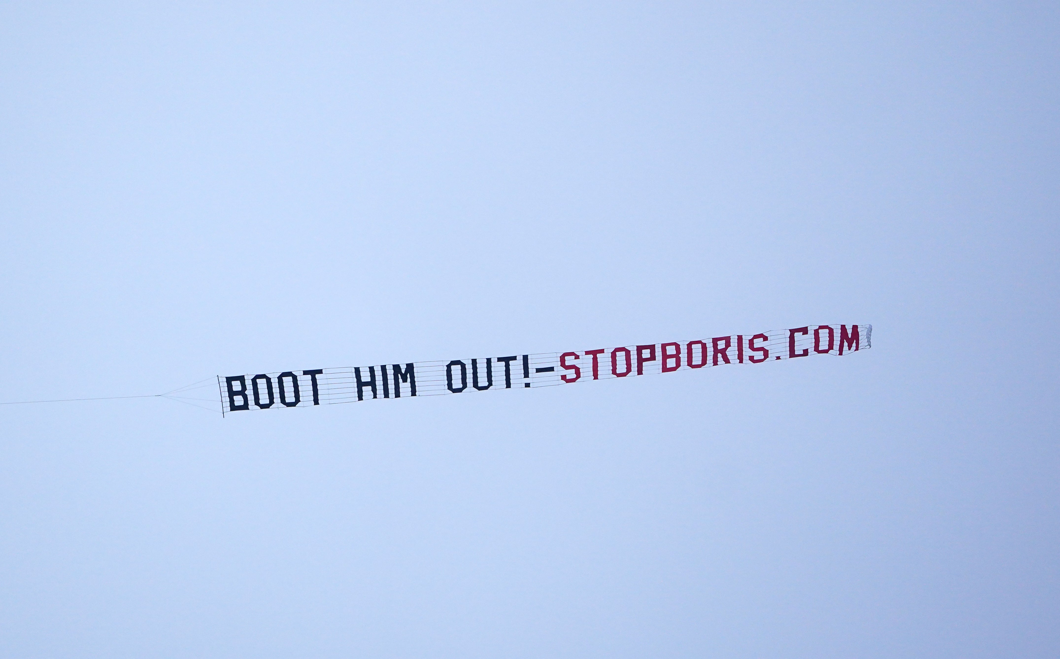 A sign protesting against Prime Minister Boris Johnson is flown over Manchester United’s Premier League match with West Ham at Old Trafford, Manchester (PA)