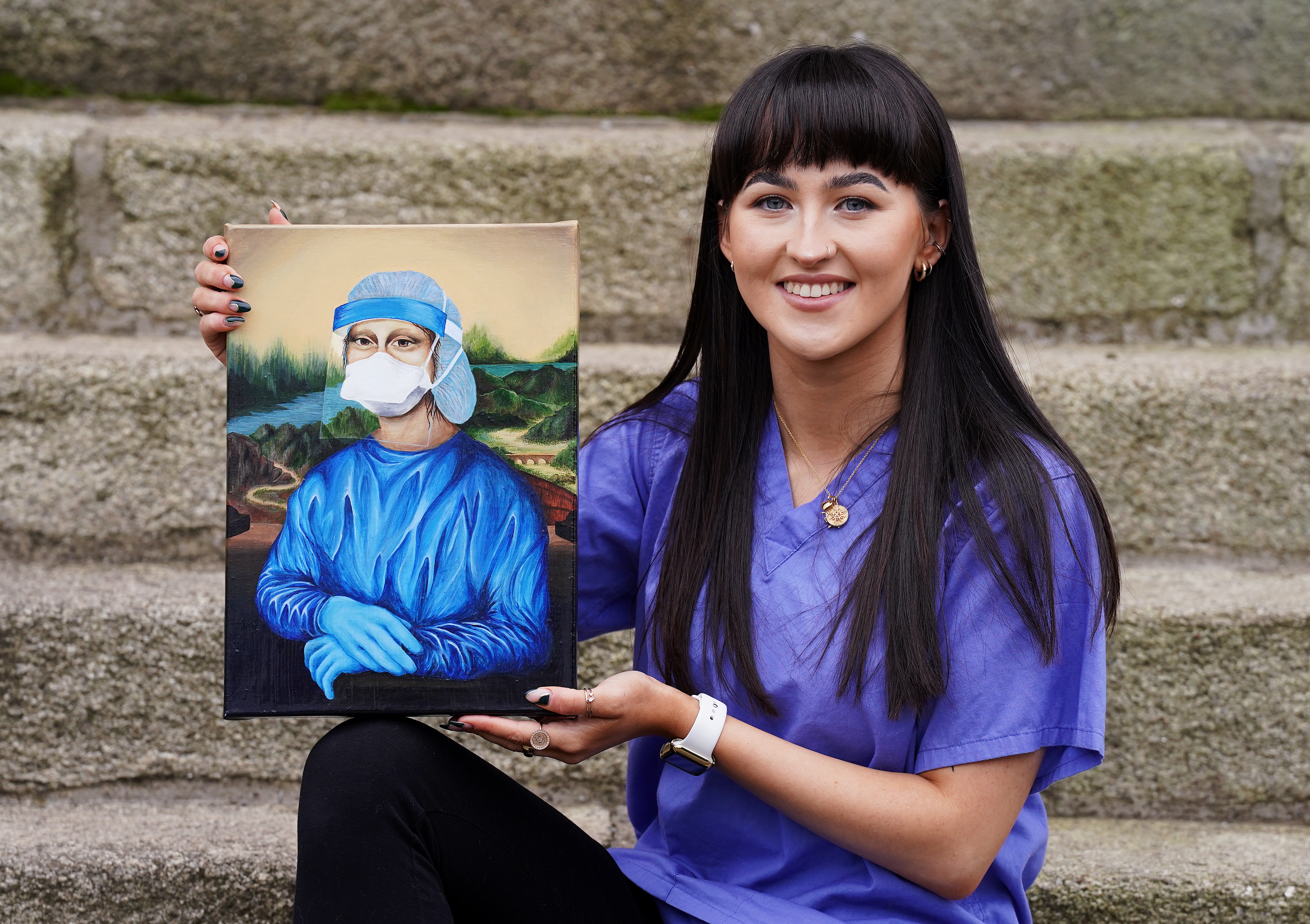 Trainee nurse Chloe Slevin with her painting Corona Lisa, which she is to auction for charity (Brian Lawless/PA)