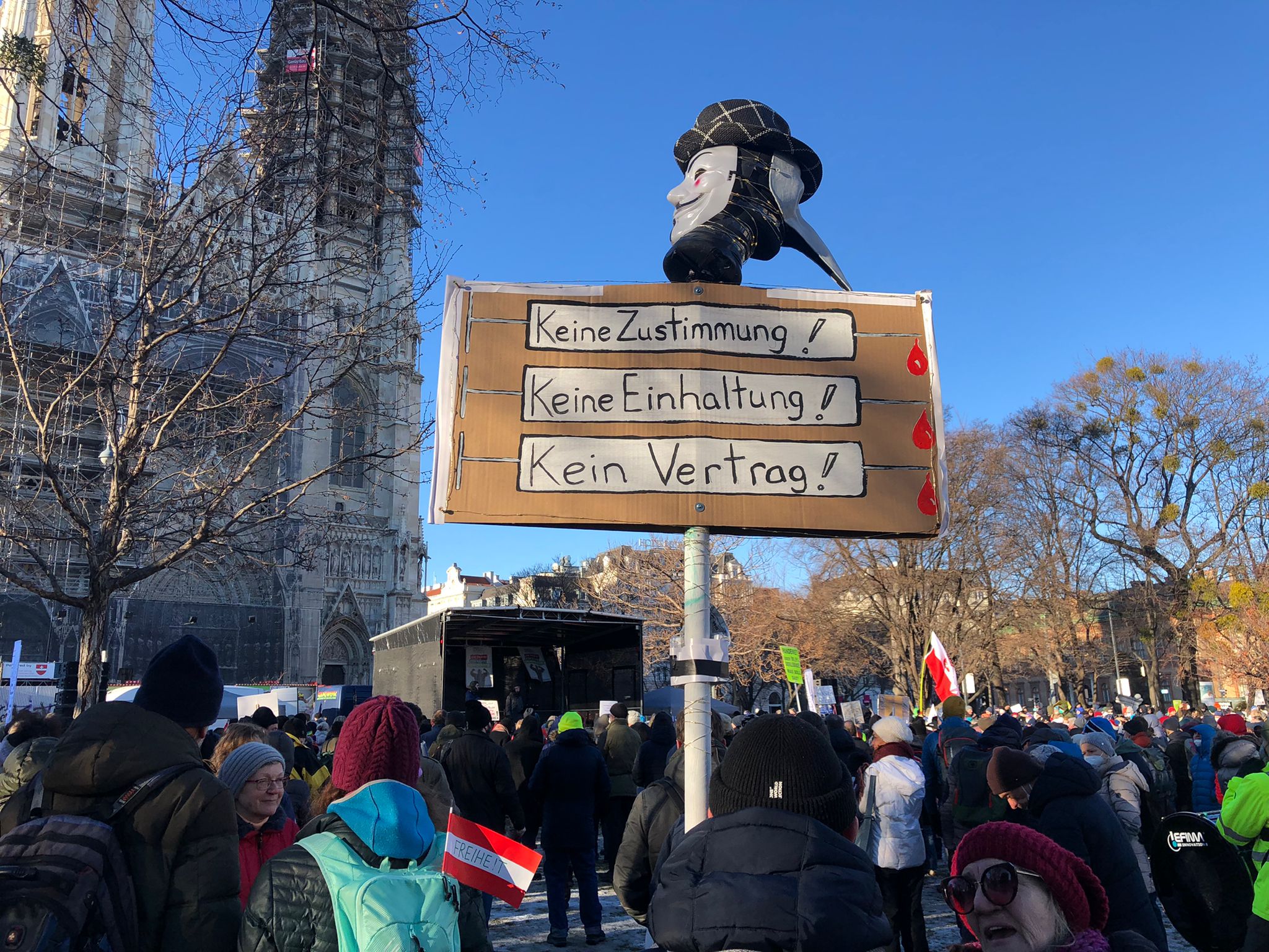 An Austrian protester holds a sign that reads ‘No agreement! No compliance! No contract!’ at a rally against mandatory vaccination in Vienna, 22 January 2022