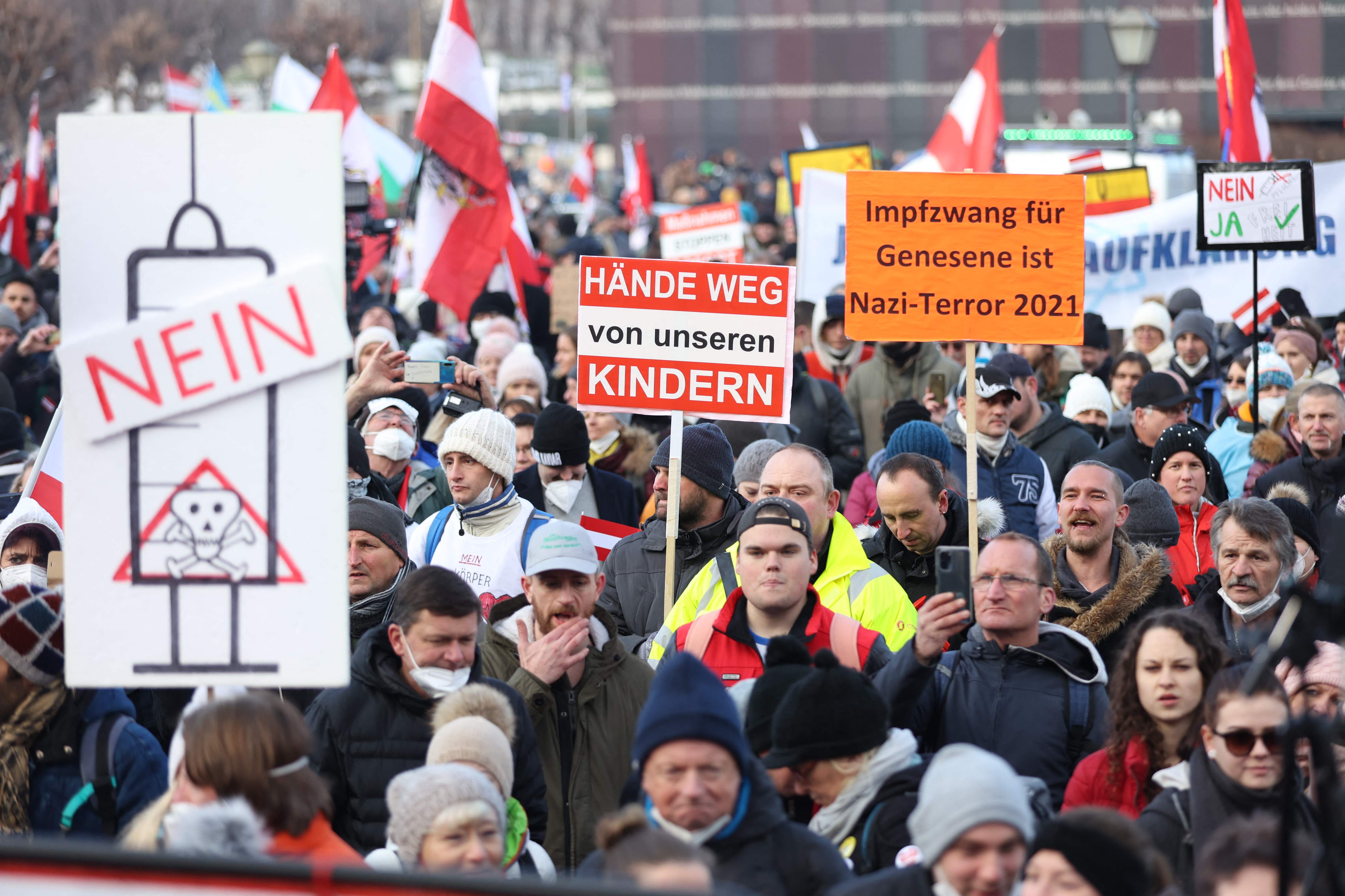 People demonstrate with placards reading “Hands off our children” and “Compulsory vaccination for recovered people is Nazi-terror 2021” in Vienna on 8 January 2022