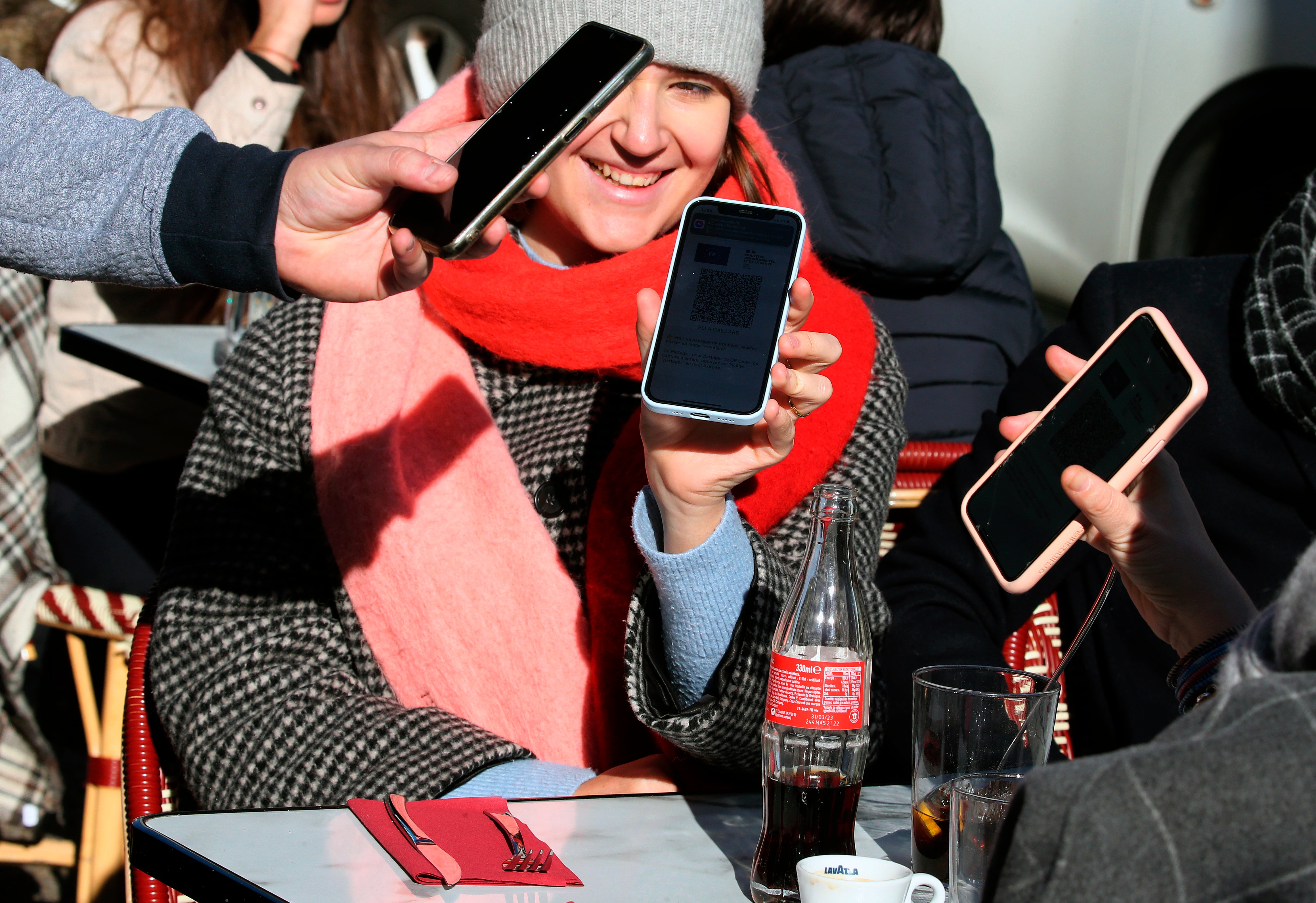 Clients showing a restaurant’s waiter their ‘vaccine passes’ in France