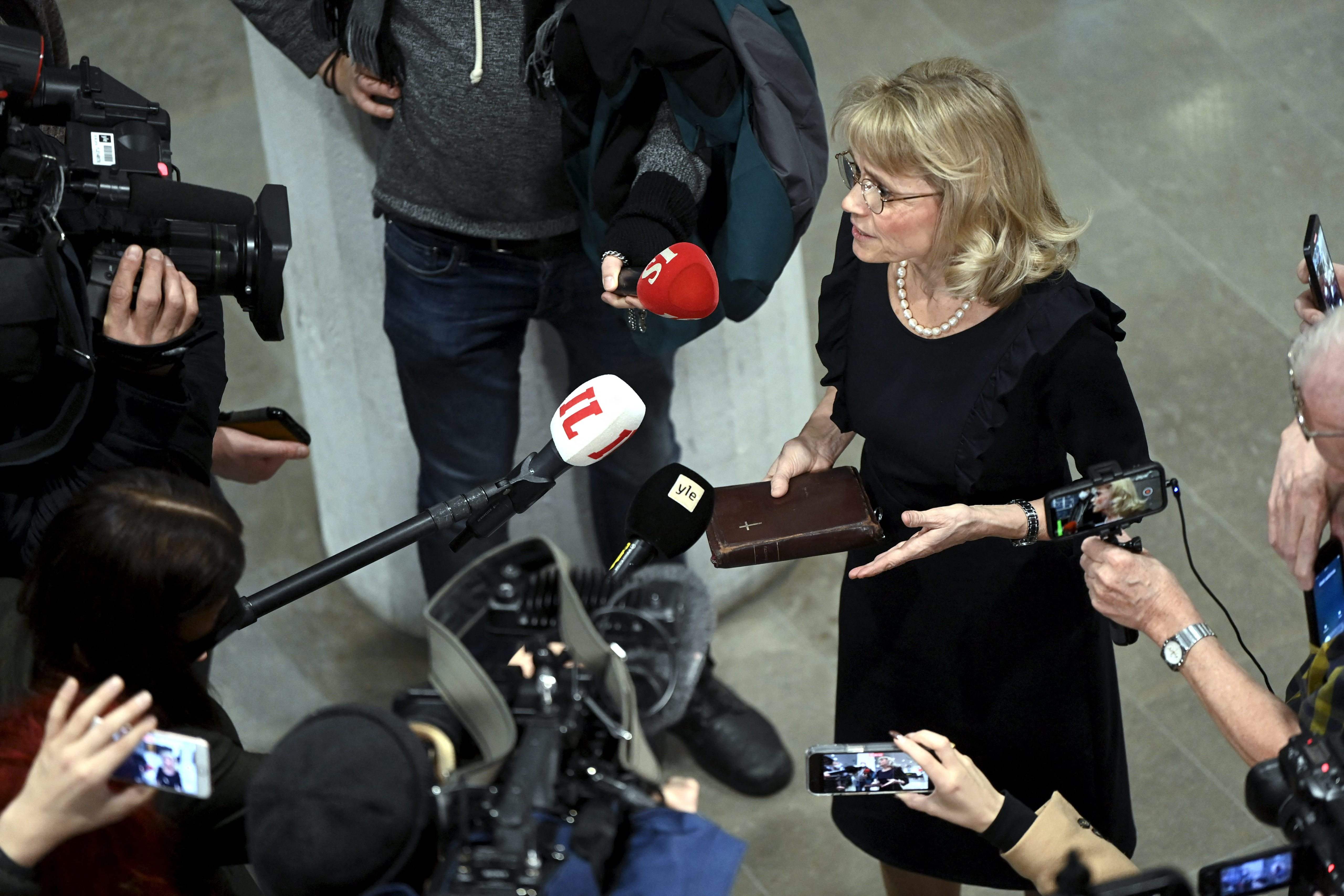 Paivi Rasanen holding the Bible outside the court