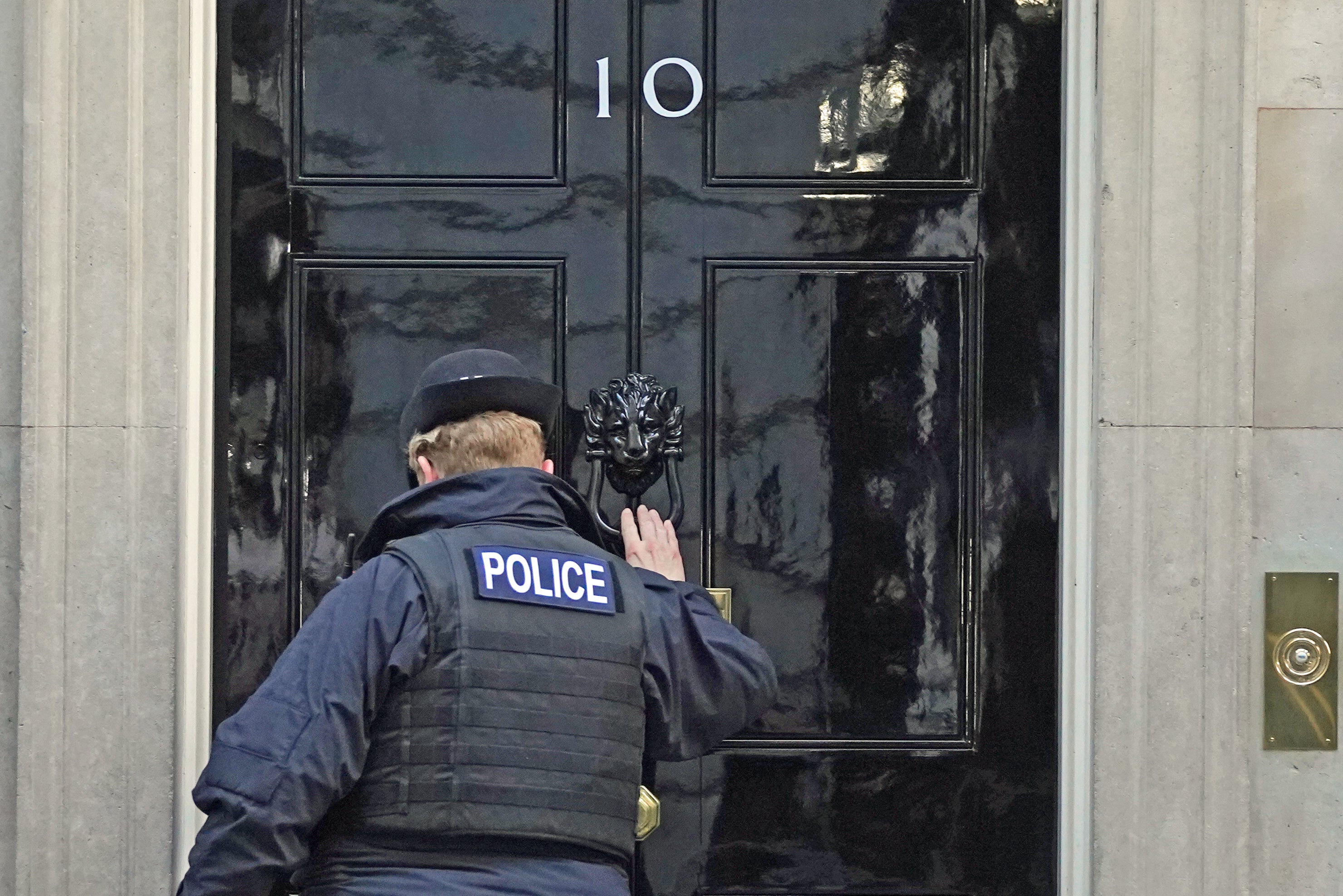 A police officer knocks on the door of the Prime Minister’s official residence in Downing Street, Westminster, London (Stefan Rousseau/PA)