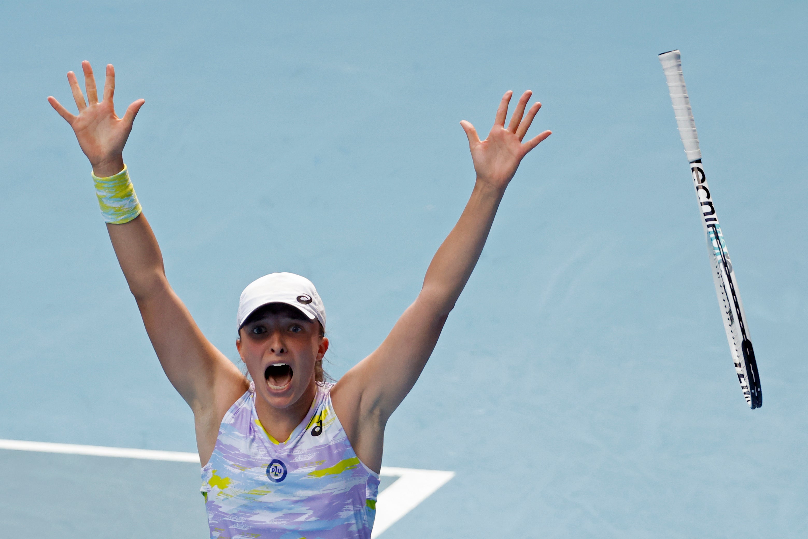 Iga Swiatek throws her racket in the air after beating Kaia Kanepi (Hamish Blair/AP)