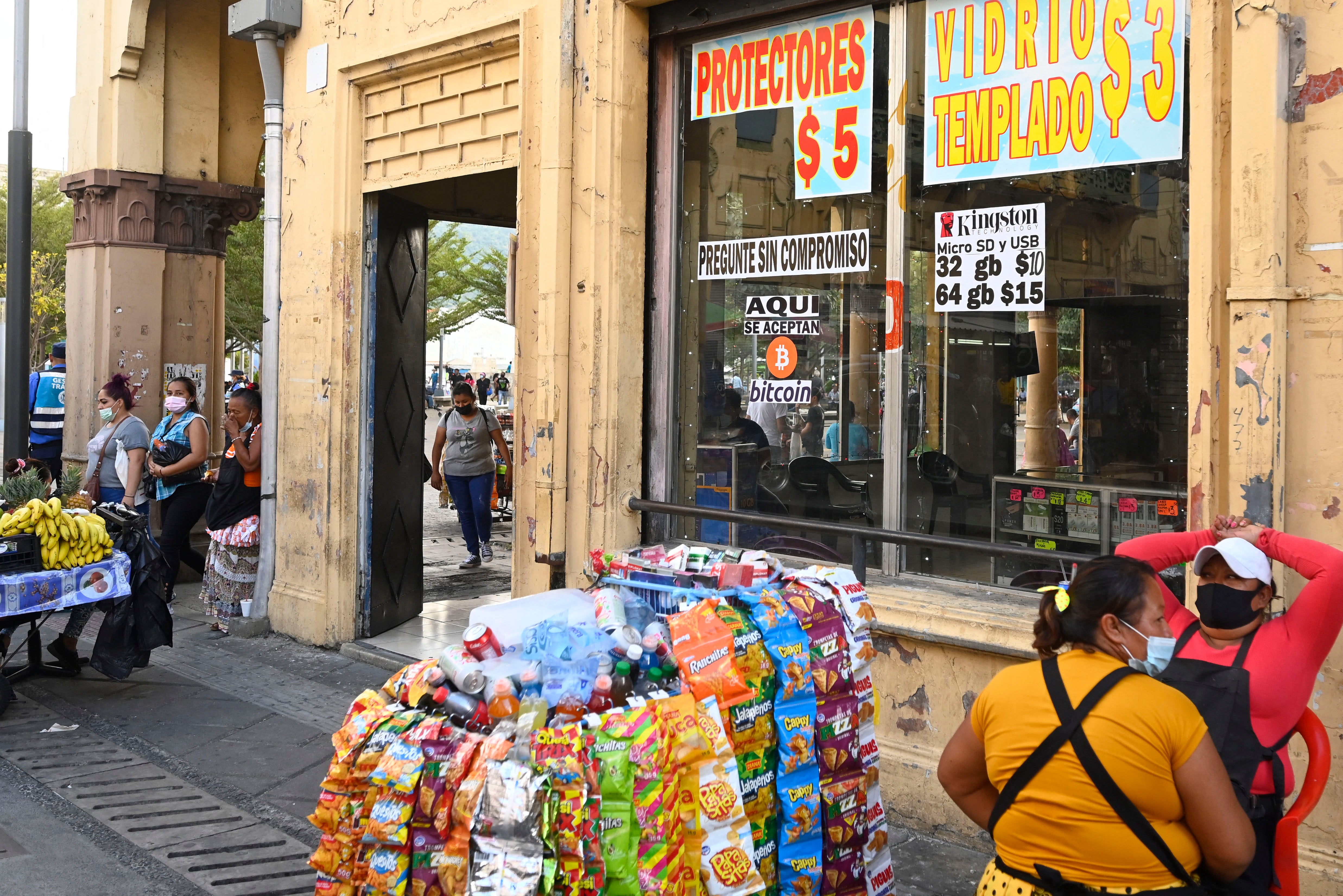 A signal that reads ‘We accept bitcoin here’ is seen outside a store in San Salvador