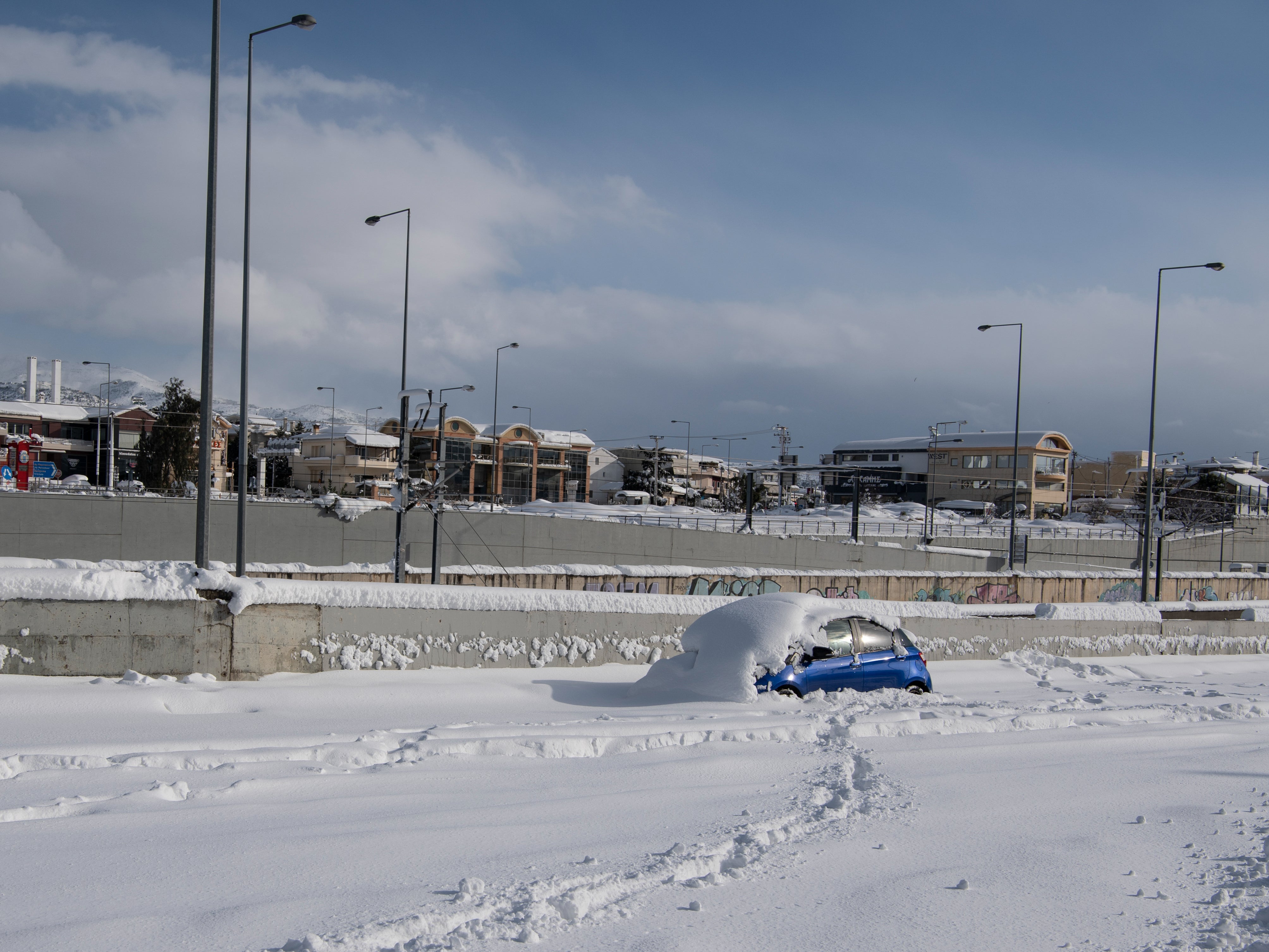 An abandoned vehicle is seen in an motorway way after a snowstorm in Athens on 24 January 2022