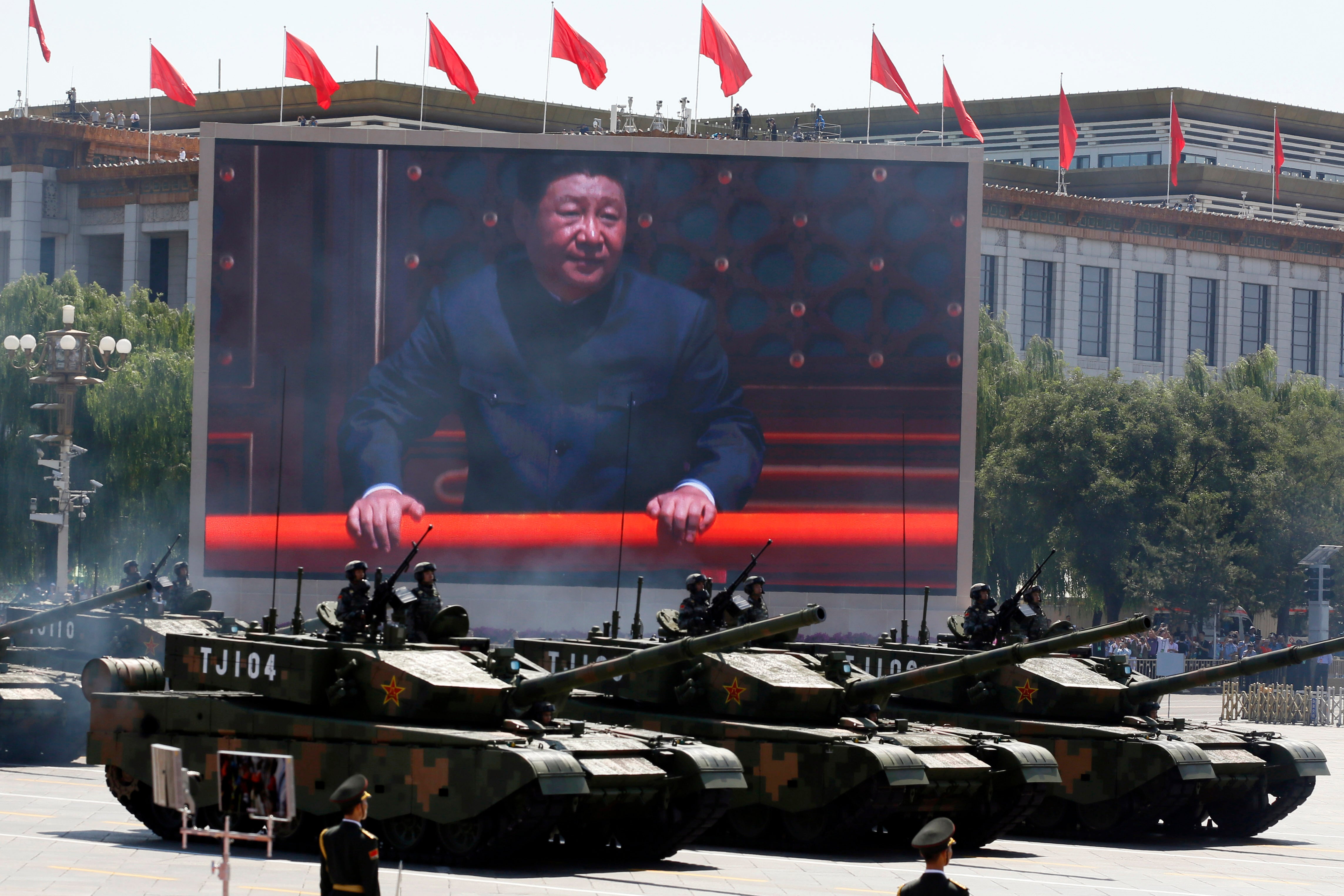 Chinese president Xi Jinping is displayed on a screen as Type 99A2 Chinese battle tanks take part in a parade