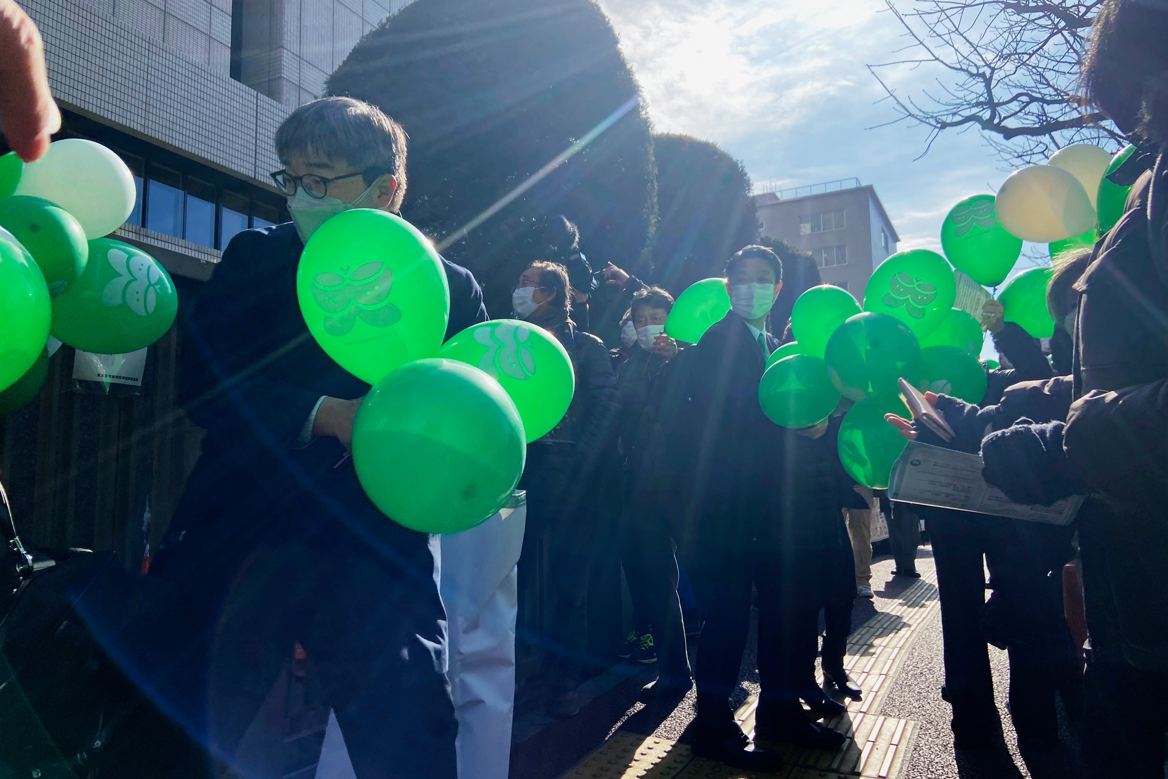 Supporters of six plaintiffs who were children at the time of the 2011 Fukushima nuclear plant disaster stand outside a court in Tokyo on 27 January