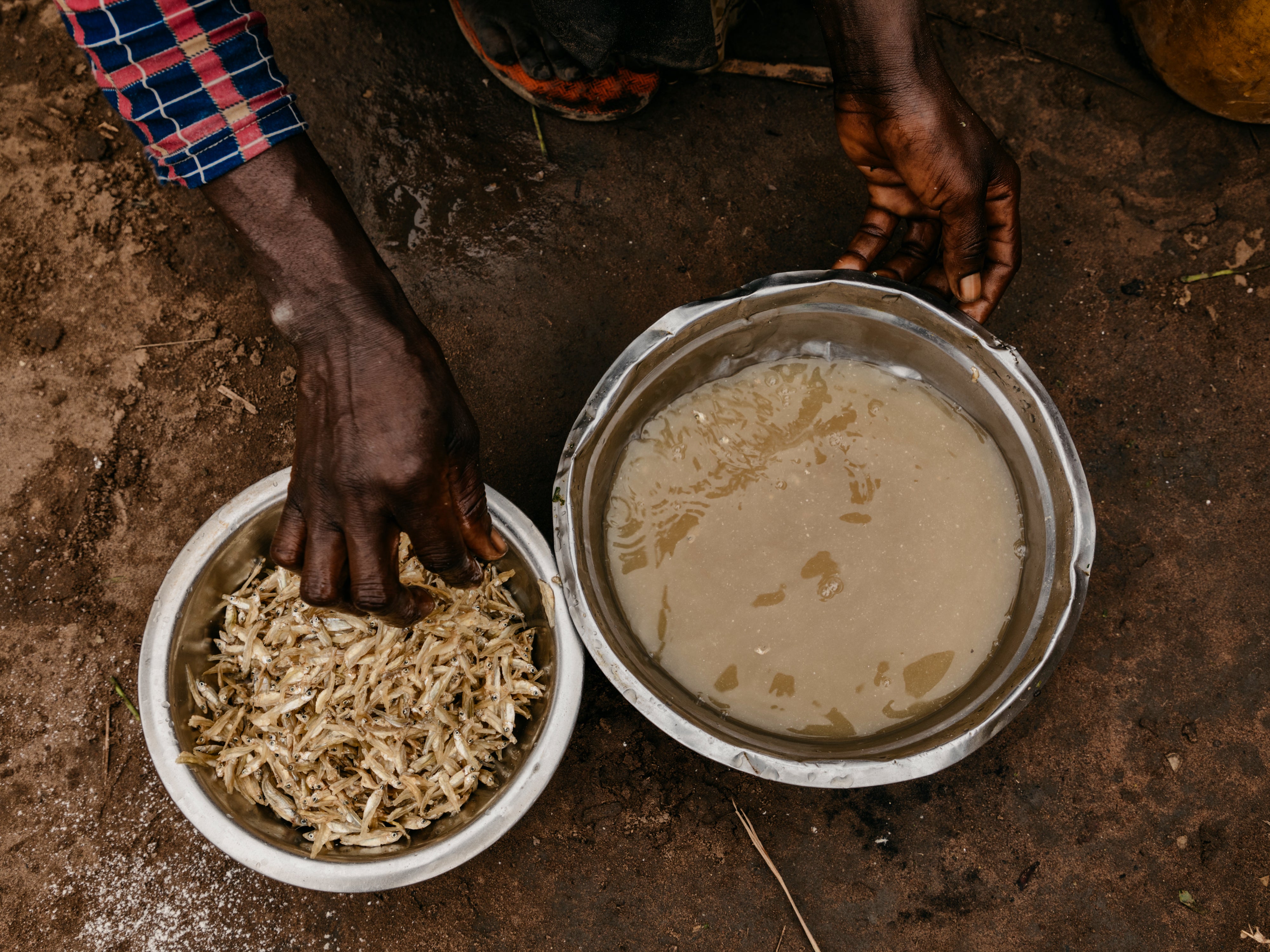 Delly* preparing food for her family at a market in her village