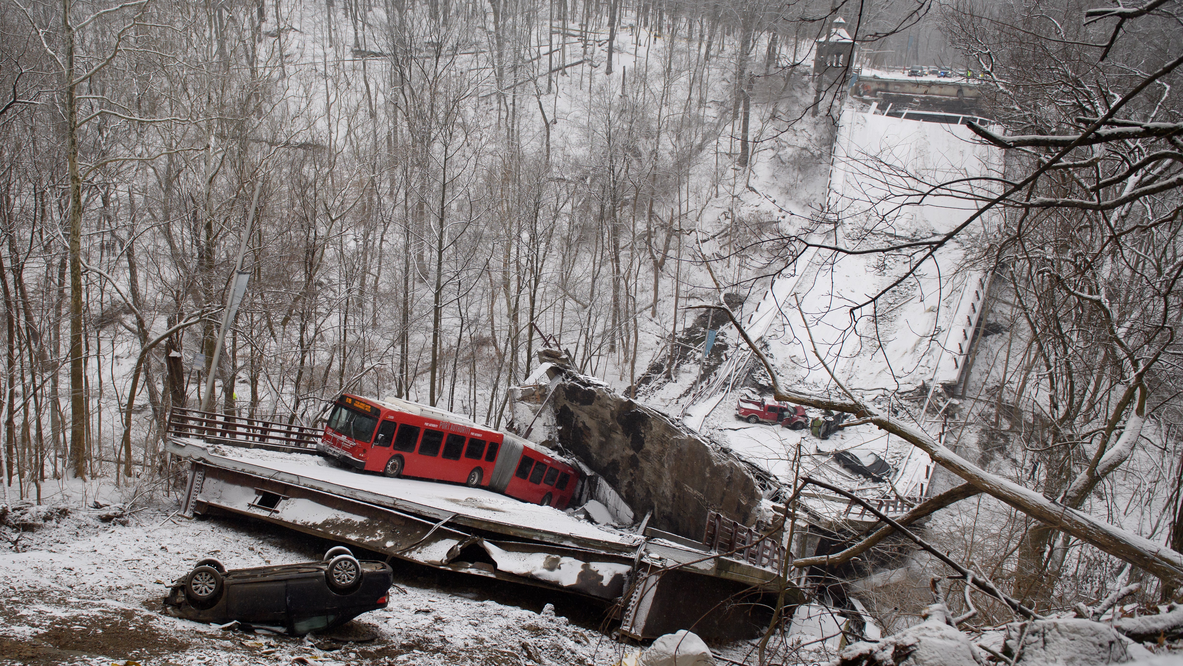 Vehicles including a Port Authority bus are left stranded after a bridge collapsed along Forbes Avenue on January 28, 2022 in Pittsburgh, Pennsylvania