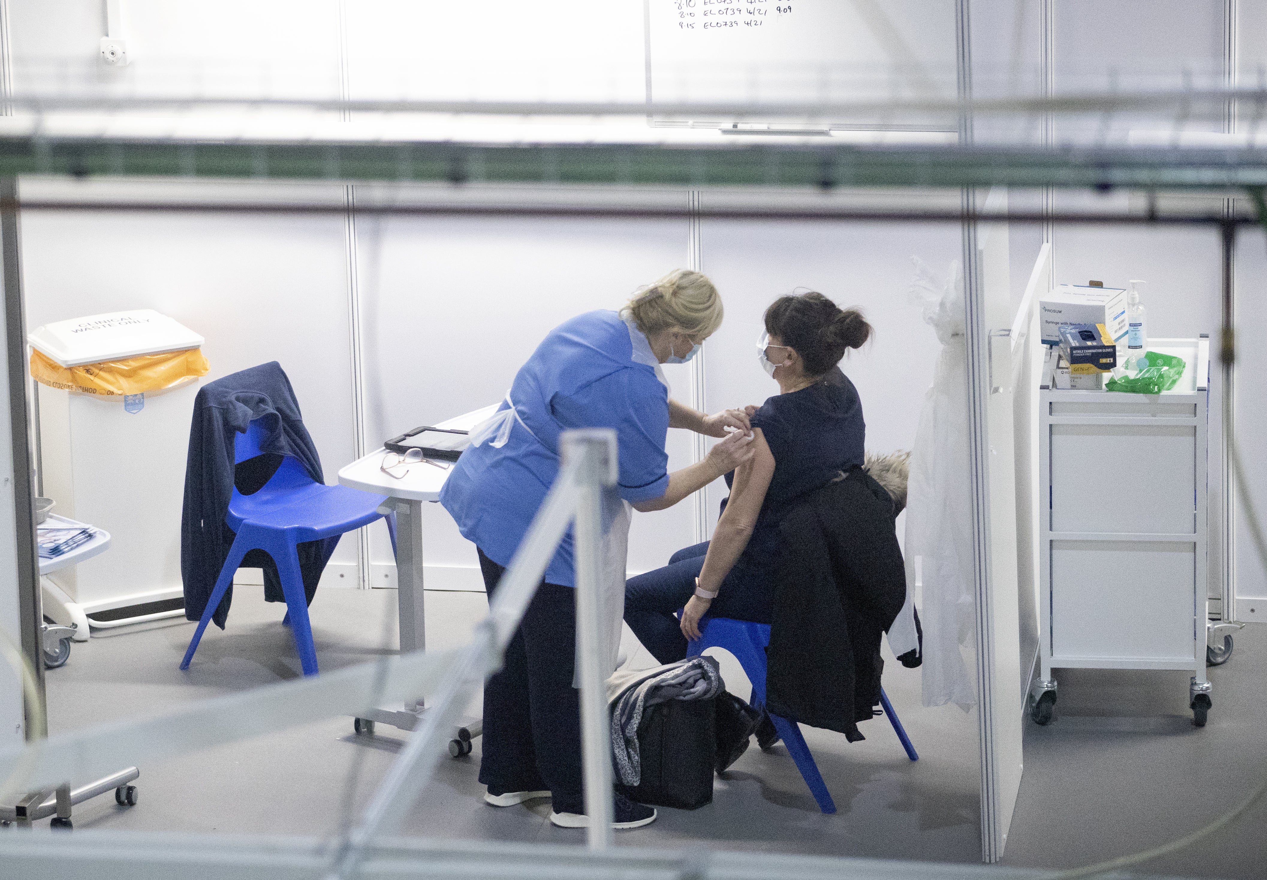 A nurse administers a coronavirus vaccine to a health and care staff member (PA)