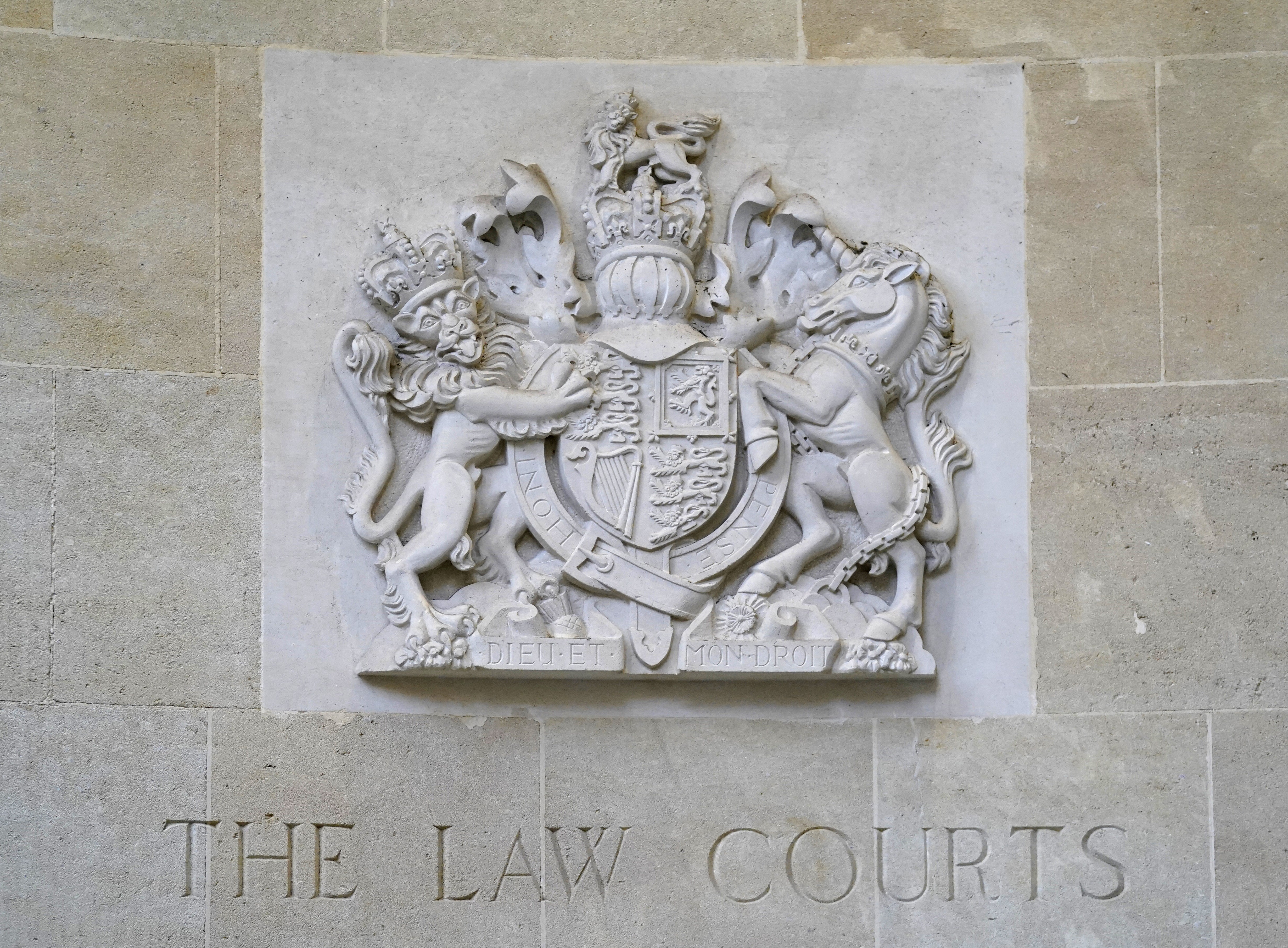 A stone carving of the royal coat of arms above a sign for The Law Courts outside the entrance to Bristol Crown Court (Andrew Matthews/PA)