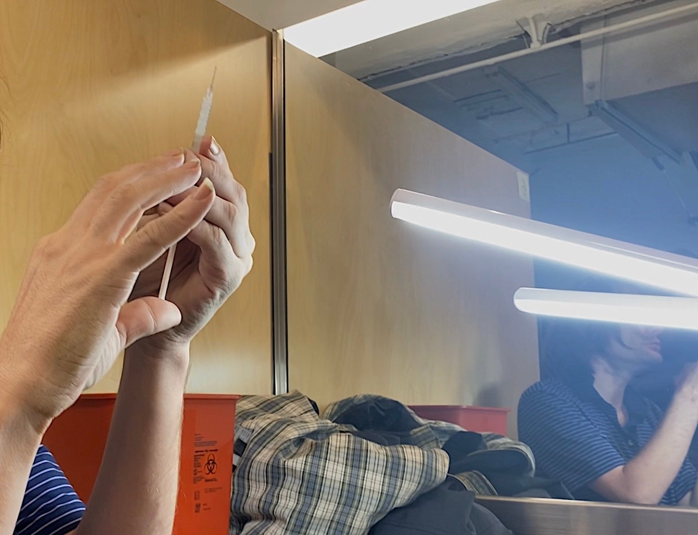 A man examines a syringe containing heroin and fentanyl at a supervised drug-injection site in Harlem, New York.