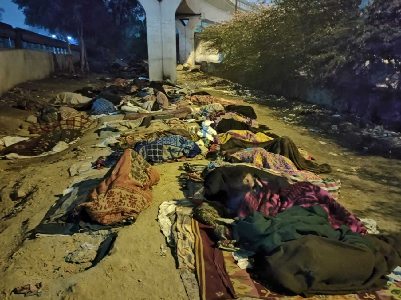 Homeless people take refuge under a bridge in Delhi as northern India’s temperature dips to extreme levels