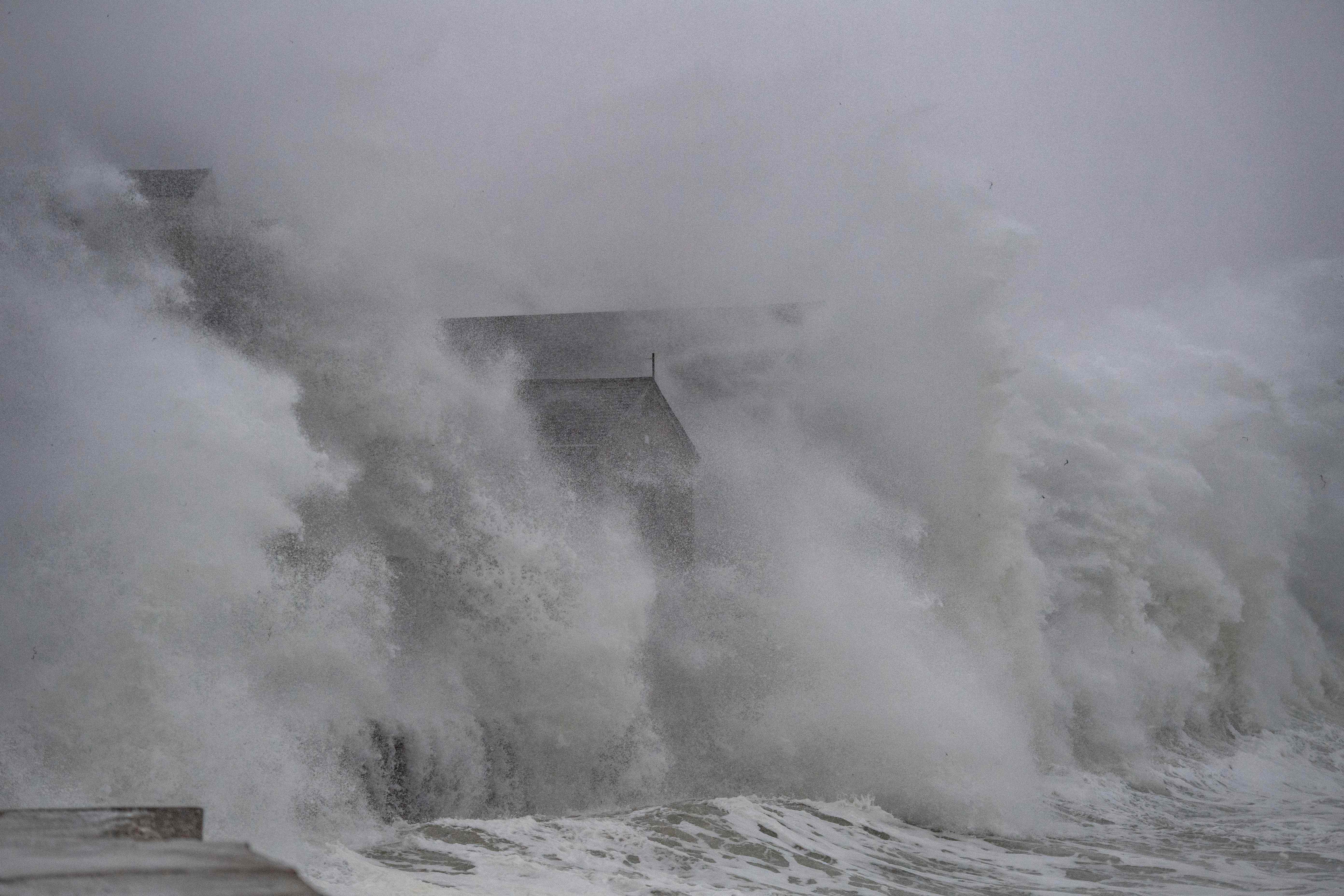 Waves crash over oceanfront homes during a noreaster in Scituate, Massachusetts, on January 29, 2022. Climate change is making storms more powerful compounding coastal issues of sea-level rise and erosion