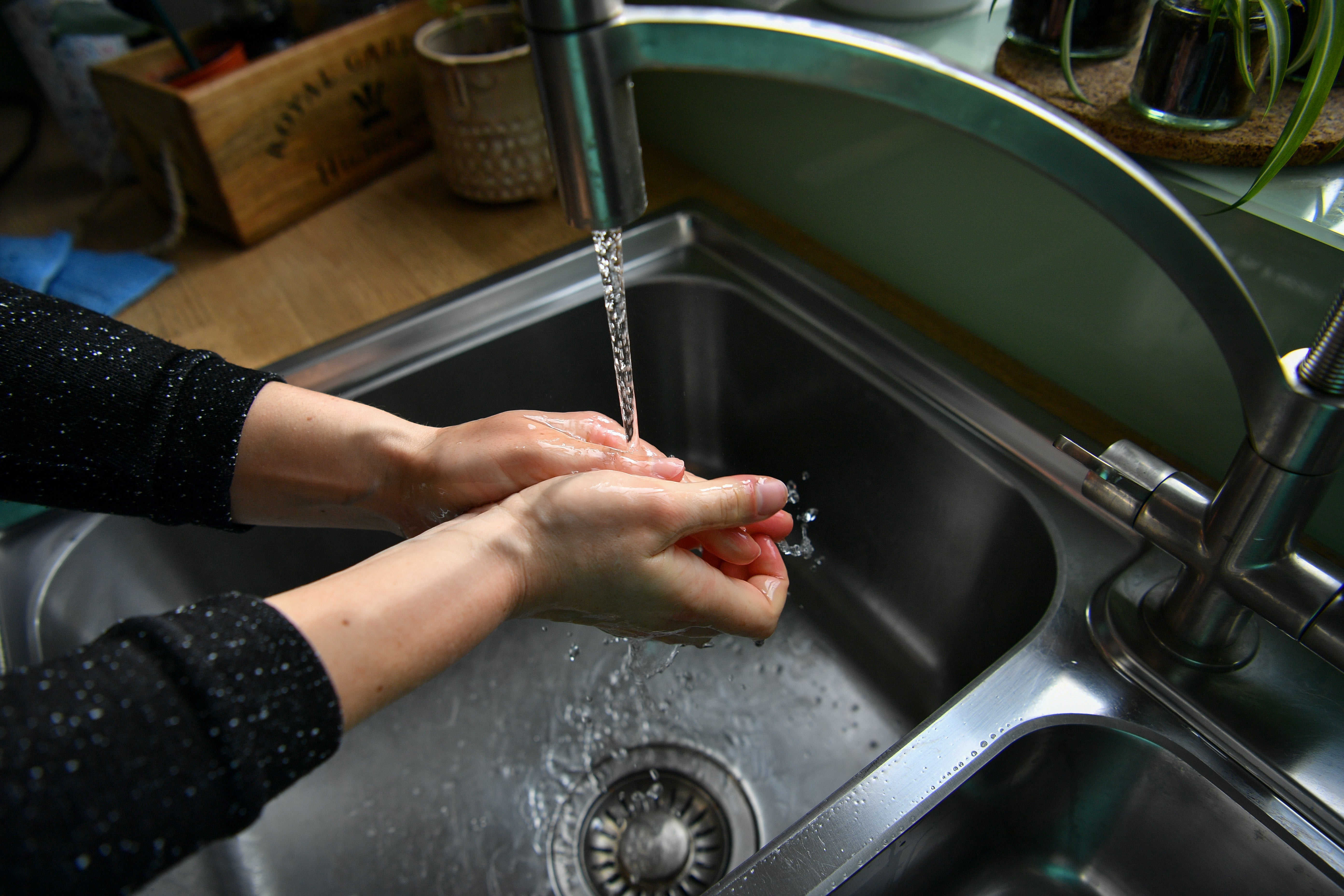 A woman washes her hands.